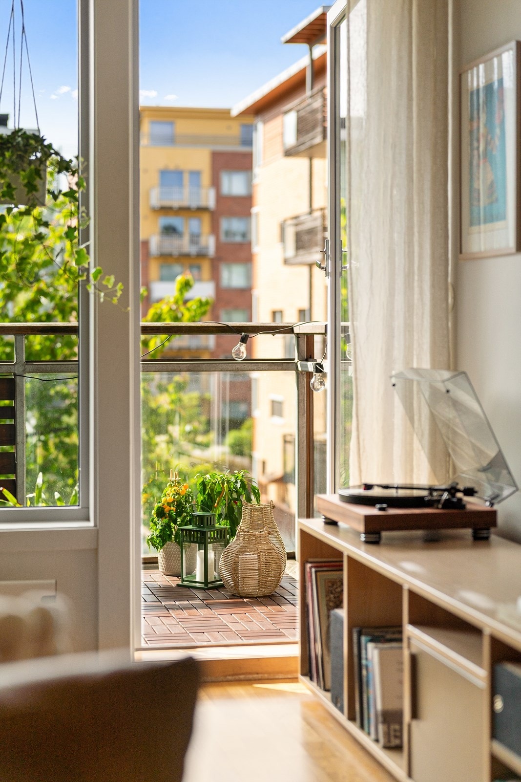 Ut til balkong fra stue. Blomstrende kirsebærtrær utenfor balkong. Galleribilde