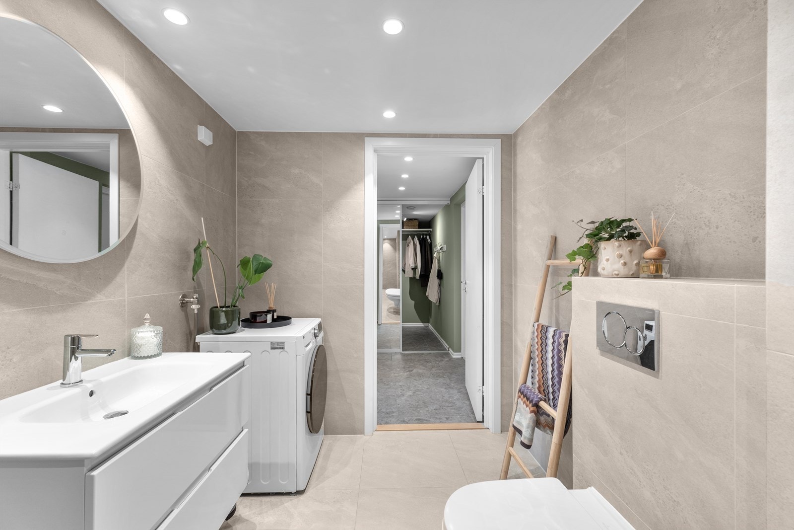 Servant med skuffer, vegghengt wc med innebygget sisterne og opplegg for vaskemaskin og tørketrommel. Galleribilde