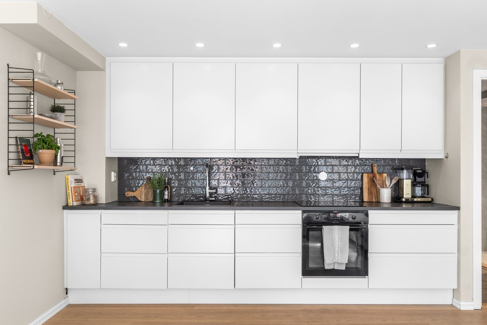 Stilrent og moderne HTH-kjøkken fra 2015 med integrerte hvitevarer og laminat benkeplate. Galleribilde