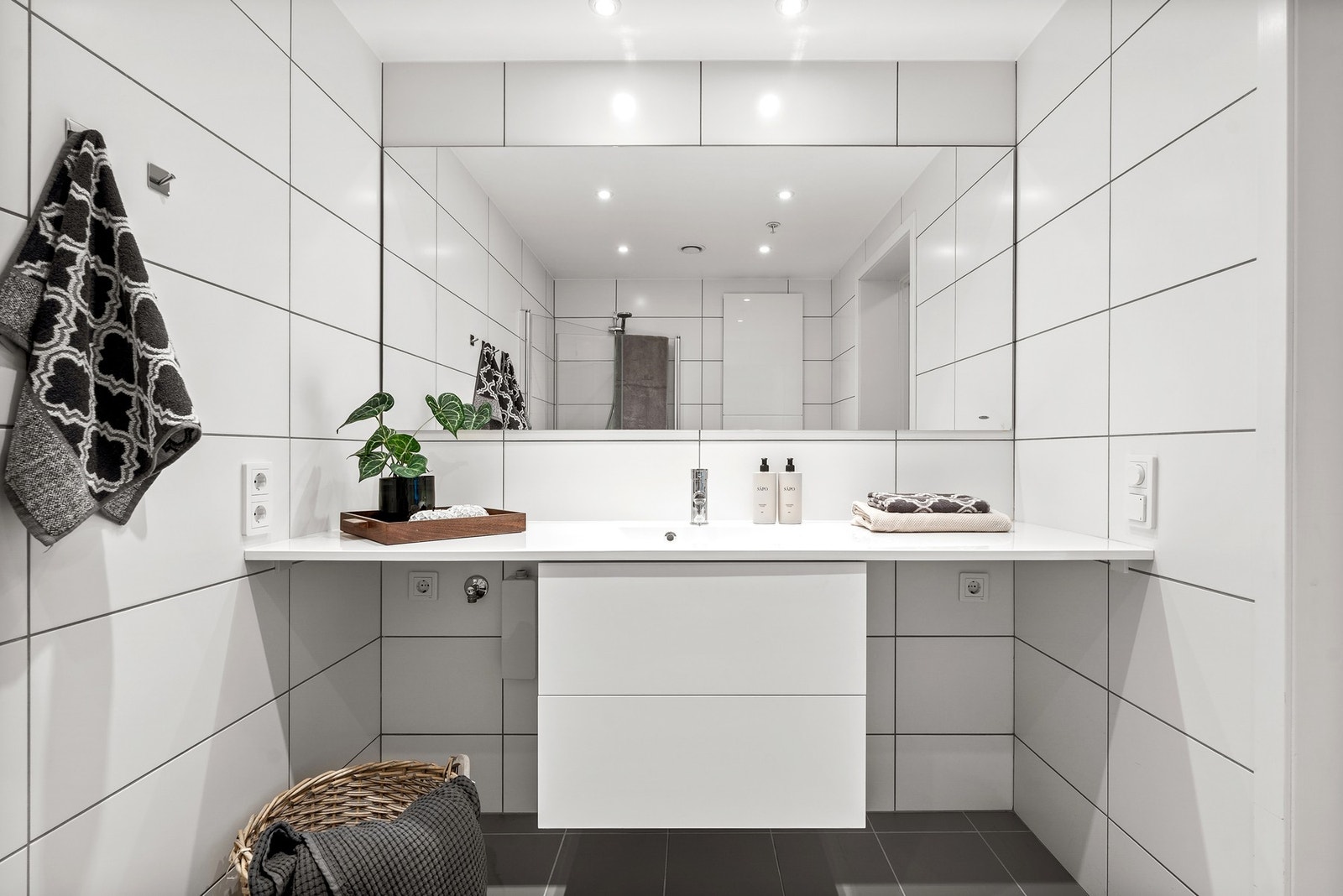 Store speilflater, downlights og rene linjer gir badet et moderne preg. Galleribilde
