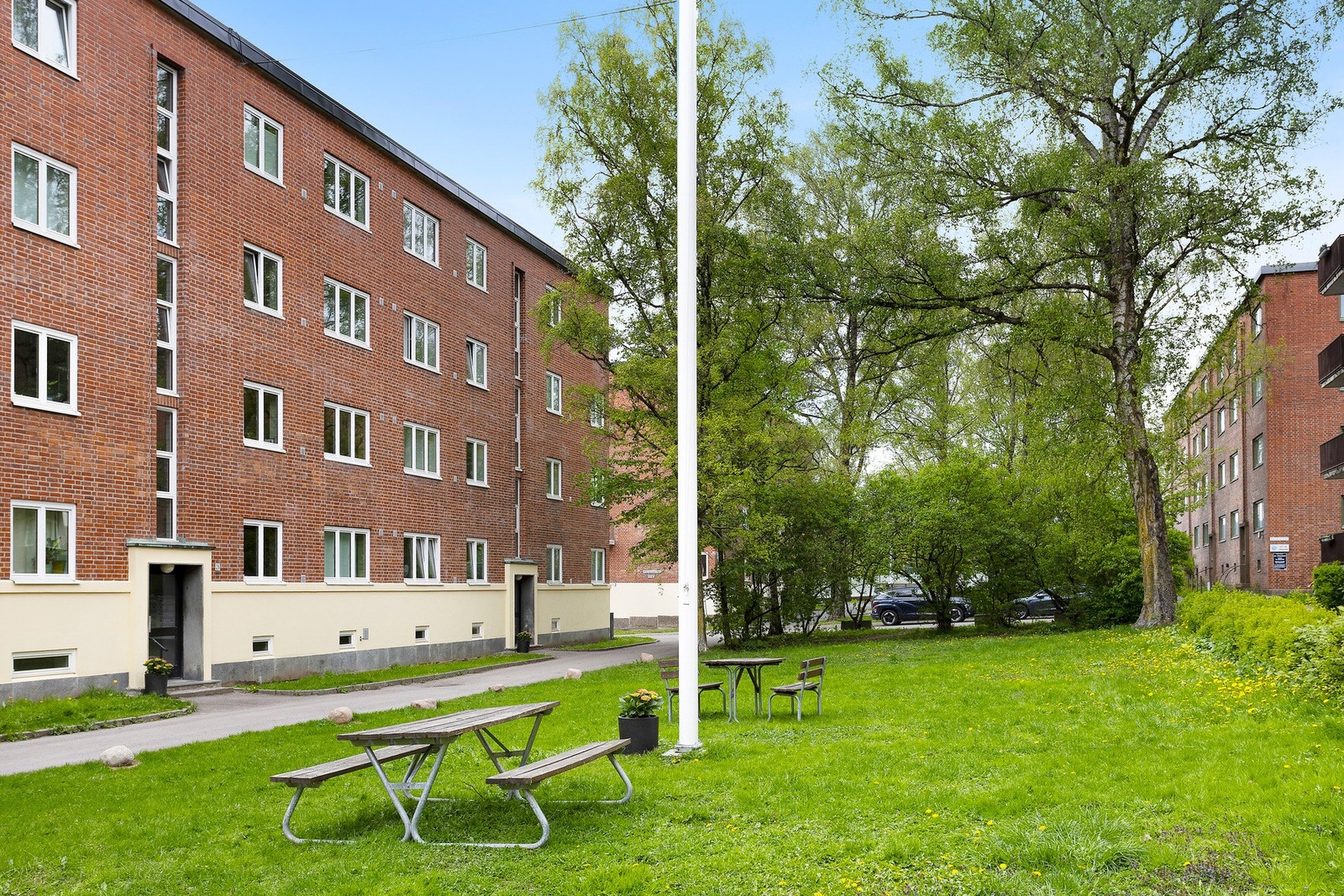 Fellesarealet er pent opparbeidet med gressplen, sitteplasser, asfalterte veier og beplantning. Galleribilde