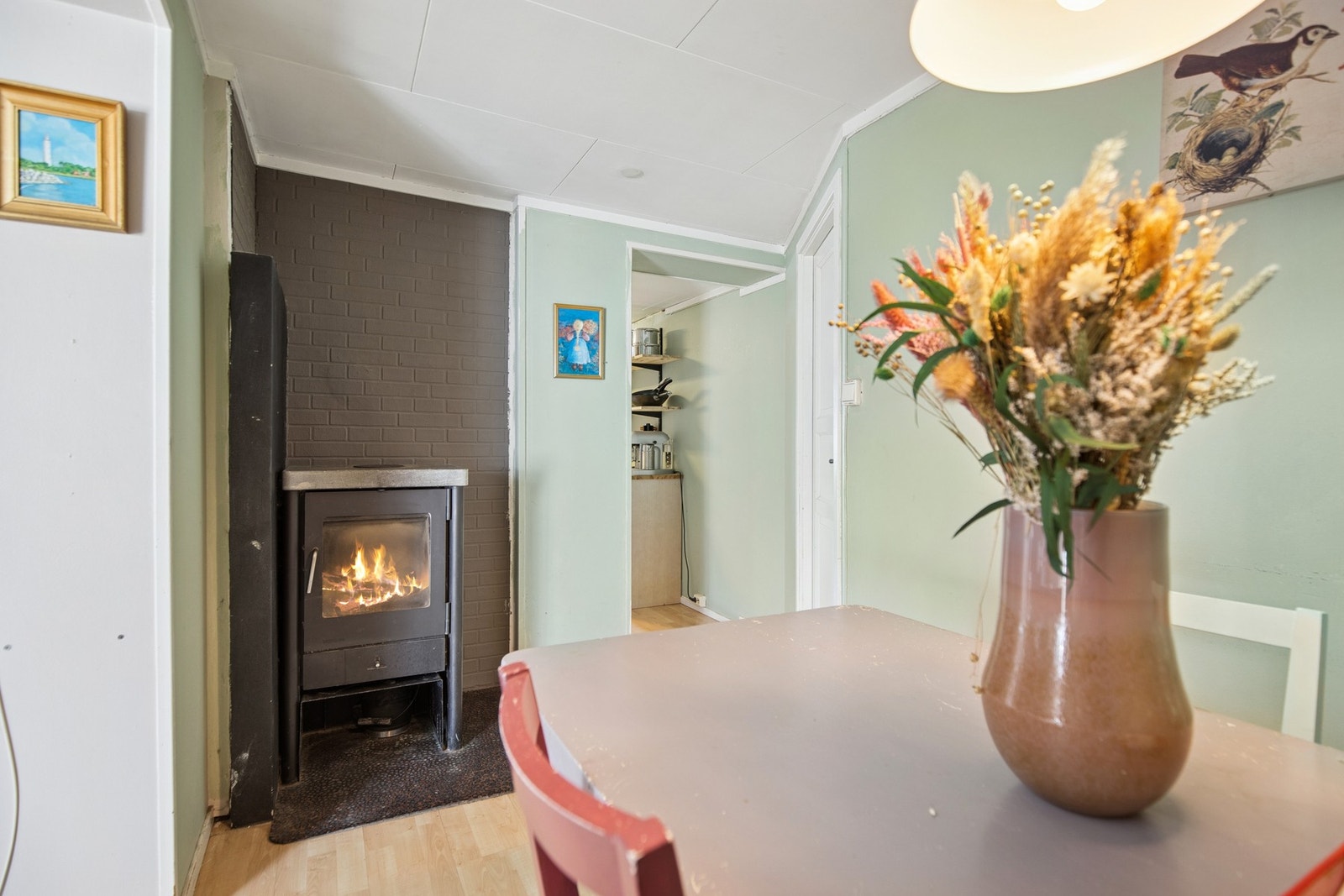 Ved spiseplassen står en vedovn som gir god varme og bidrar til en lun atmosfære i hverdagen. Galleribilde