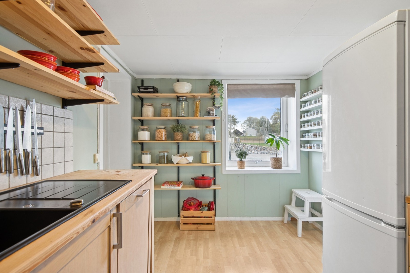 Kjøkkenet / entréen har en enkel og praktisk innredning med åpne hyller og god plass til oppbevaring. Galleribilde