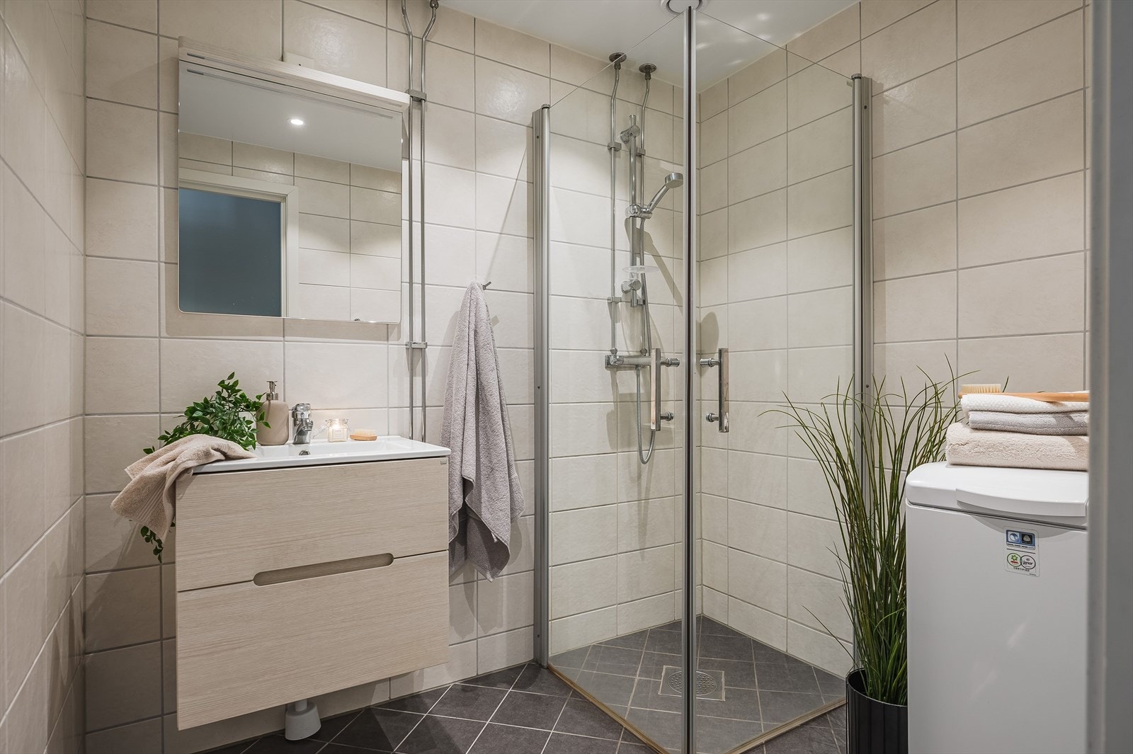 Leiligheten har et lyst og pent bad/vaskerom som ble pusset opp i regi av borettslaget i 2016. Baderommet har grå fliser på gulv med gulvvarme, lyse fliser på veggene, downlights i himlingen og mekanisk avtrekk. Galleribilde