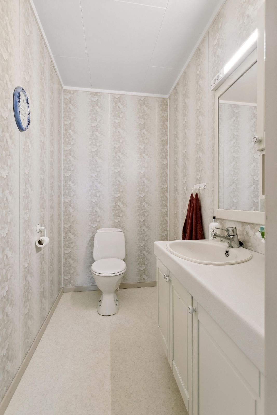 Toalettrom fra 1987 i 1. etasje med belegg på gulv, våtromsplater på veggene og mekanisk avtrekk. Rommet er utstyrt med innredning med servant, speil med belysning over, gulvstående toalett og elektrisk stråleovn. Galleribilde