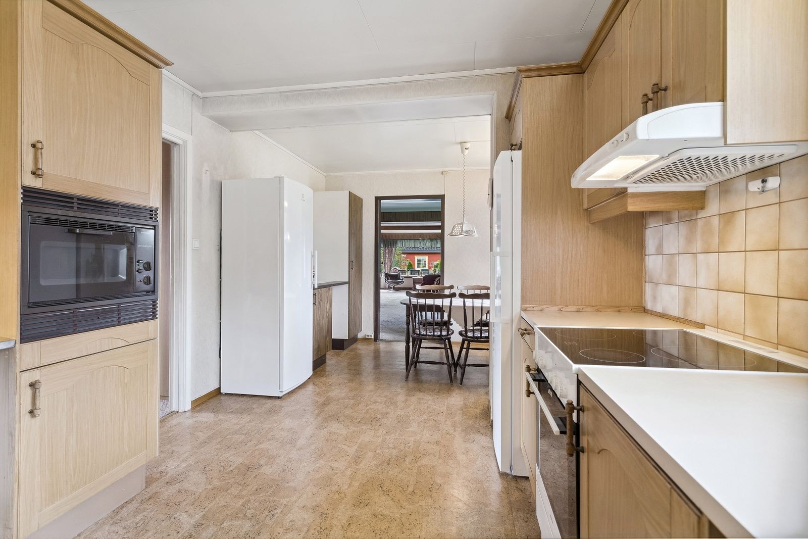 Plass til frittstående hvitevarer som komfyr, kjøleskap og oppvaskmaskin. I tilknytning til spisestuen er det eldre innredning med glatte fronter. Galleribilde