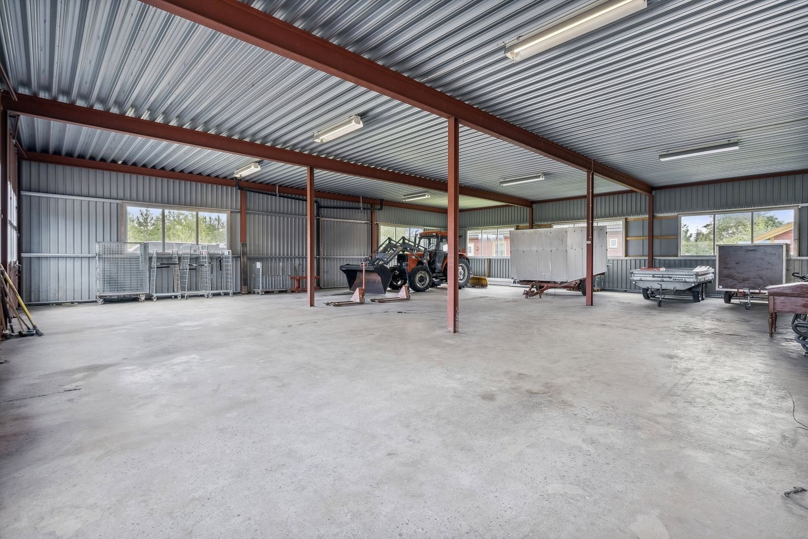 Stor garasje/verksted med betonggulv og flere store vindusflater samt kjøreporter. Galleribilde