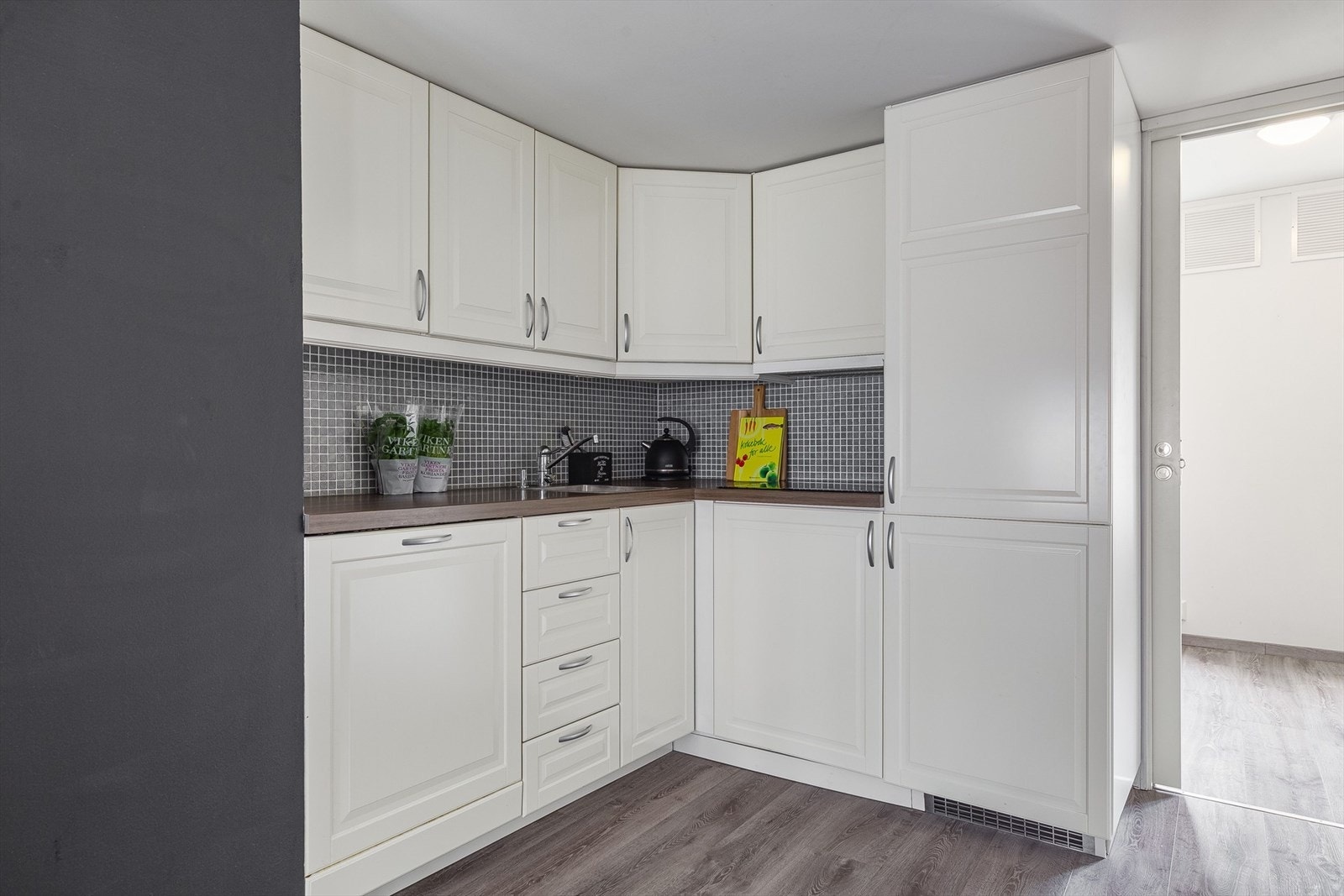 Lekkert kjøkken med integrerte hvitevarer og funksjonell innredning. Galleribilde