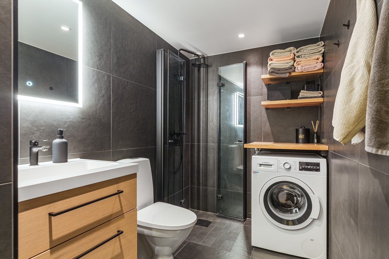 Stilrene og nyoppusset bad med regnfallsdusj og opplegg for vaskemaskin. Galleribilde