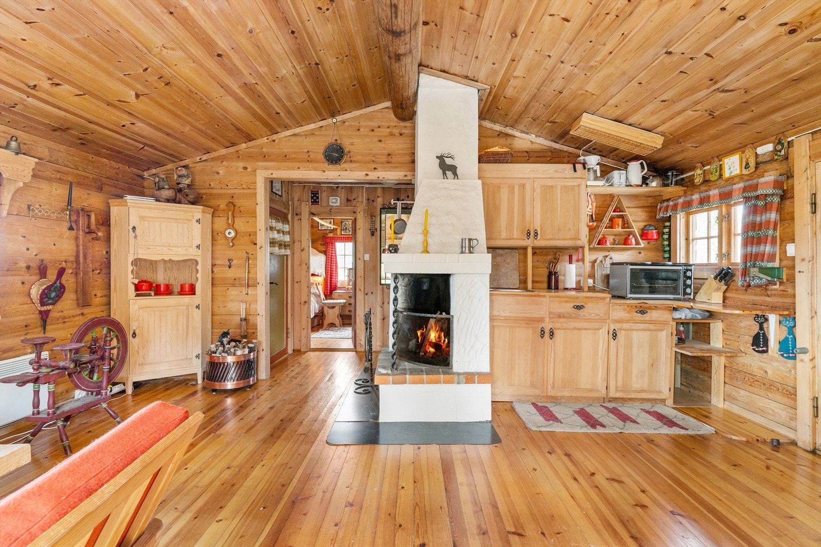 Stue og spisestue har åpen løsning med et hyggelig ildsted i midten. Galleribilde