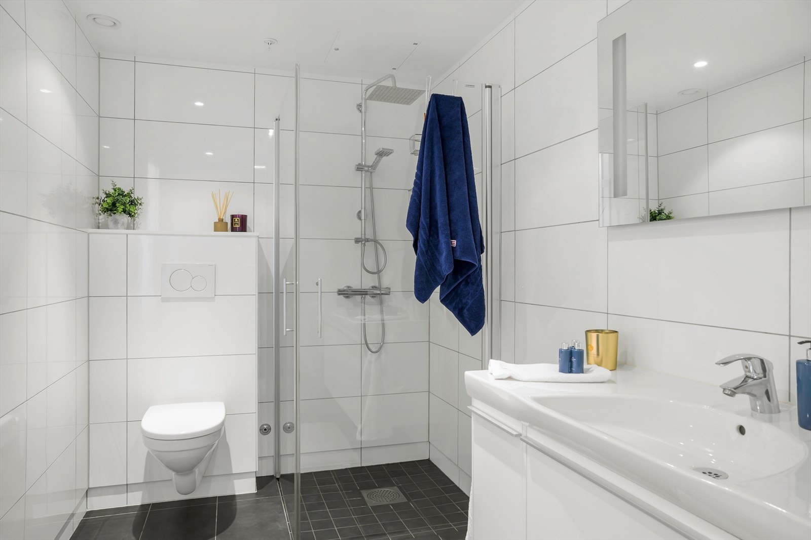 Fint helfliset bad med vegghengt wc, romslig dusjhjørne og servant i seksjon Galleribilde