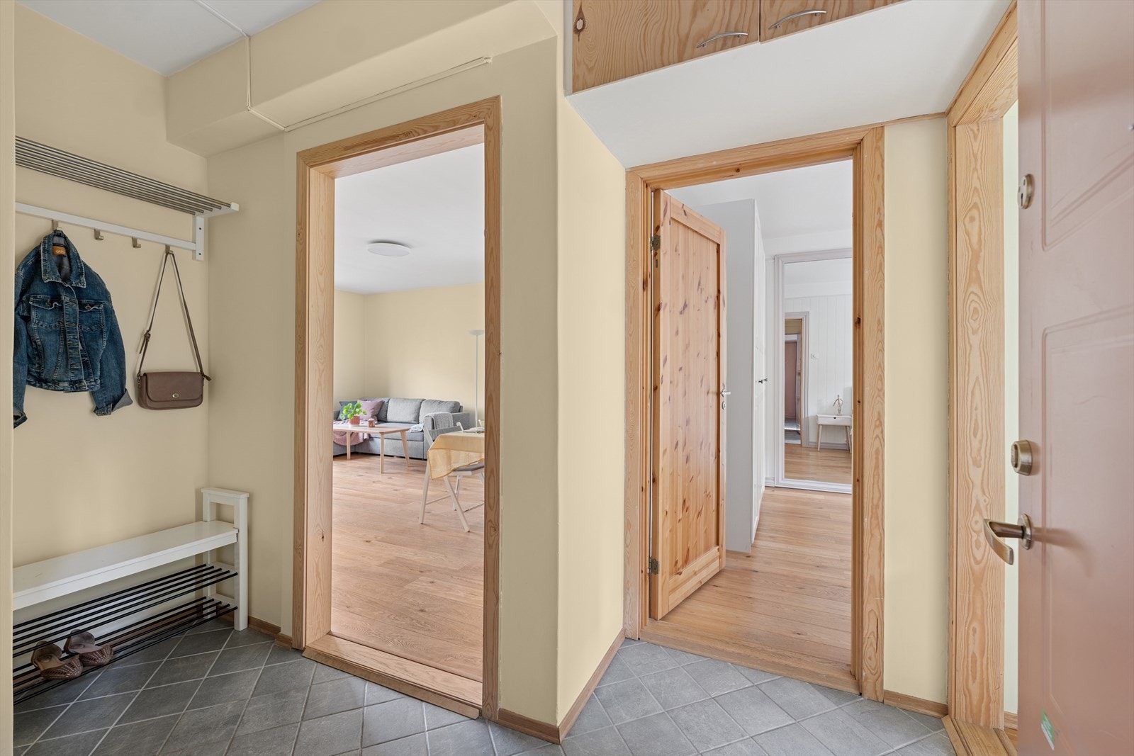 Romslig flislagt entrè tar deg inn til leilighetens øvrige rom Galleribilde