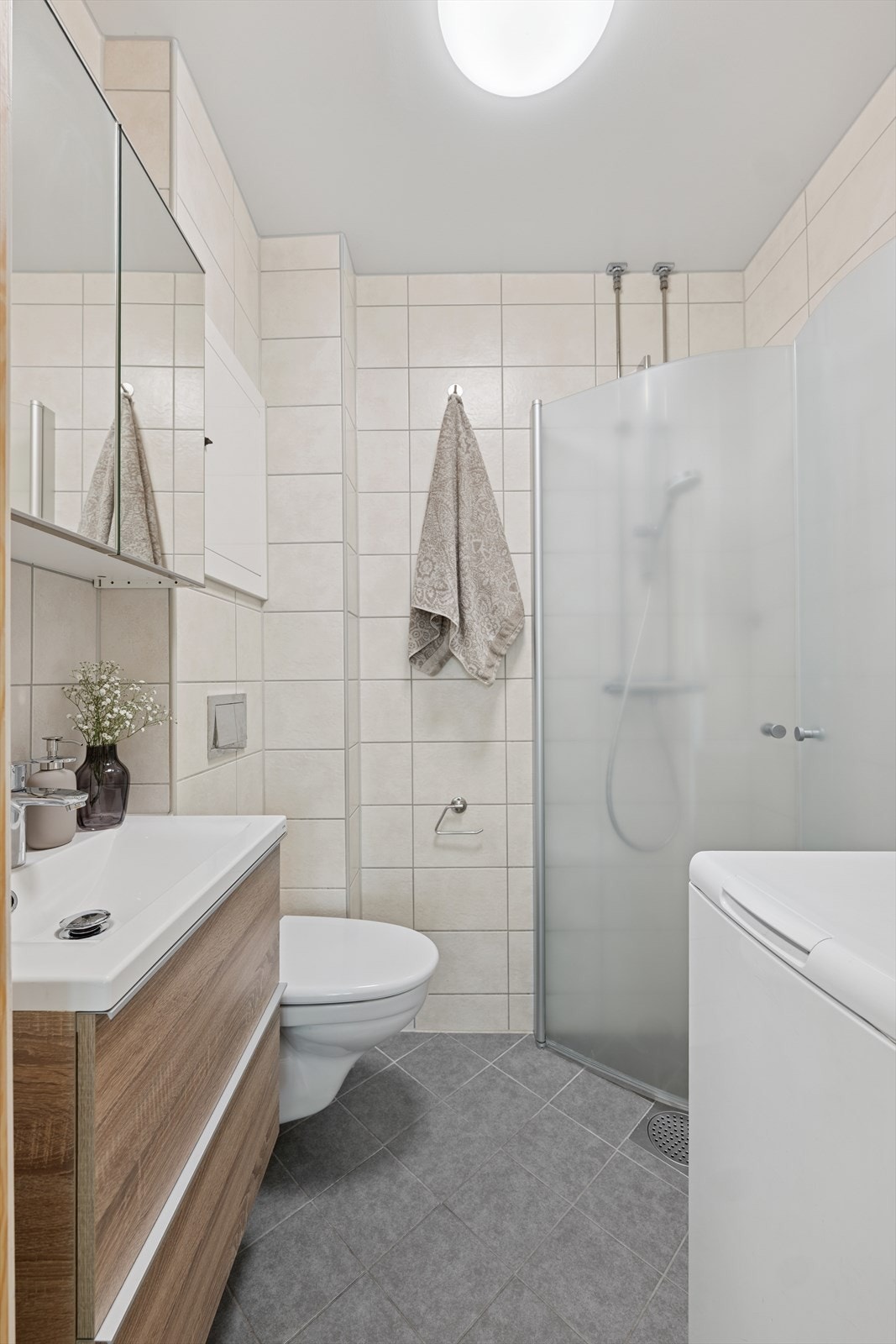 Badet er utstyrt med dusj med innfellbare dusjvegger og opplegg for vaskemaskin Galleribilde