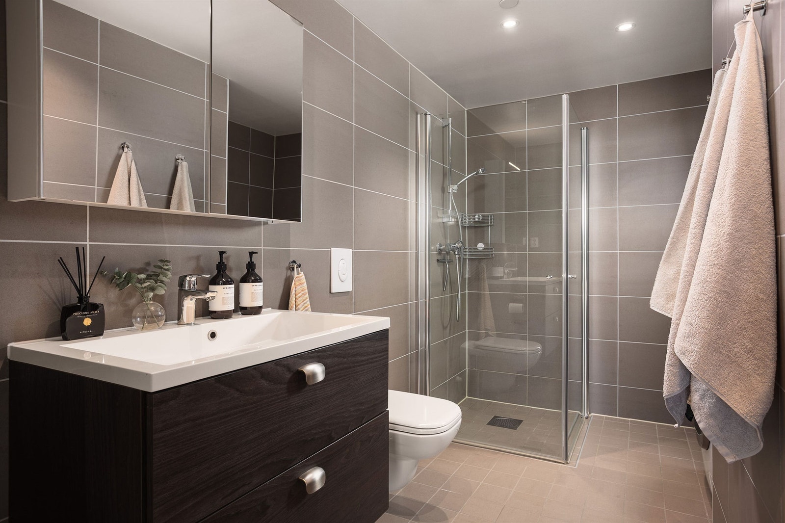 Delikat bad som er flislagt i moderne design og kvalitet. Romslig dusjhjørne, vegghengt wc. Galleribilde