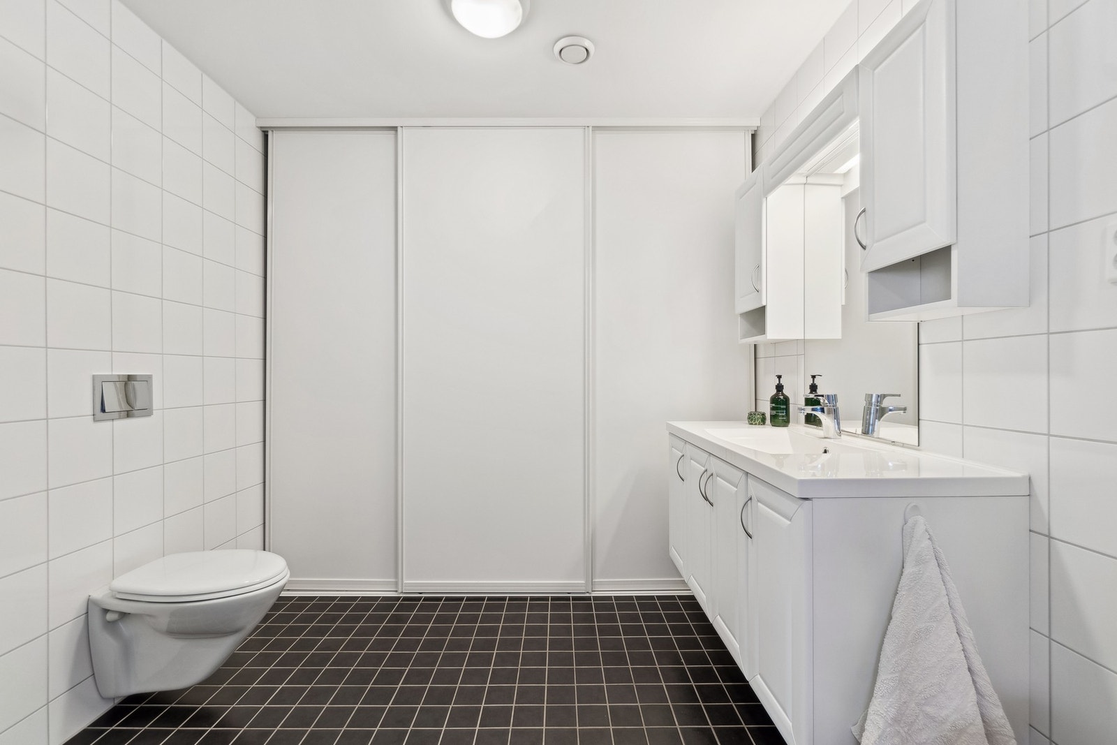 I enden av badet finner du opplegg for vaskemaskin bak skyvedører, slik at du kan stenge ute støy under drift og få badet til å fremstå mer stilrent. Galleribilde