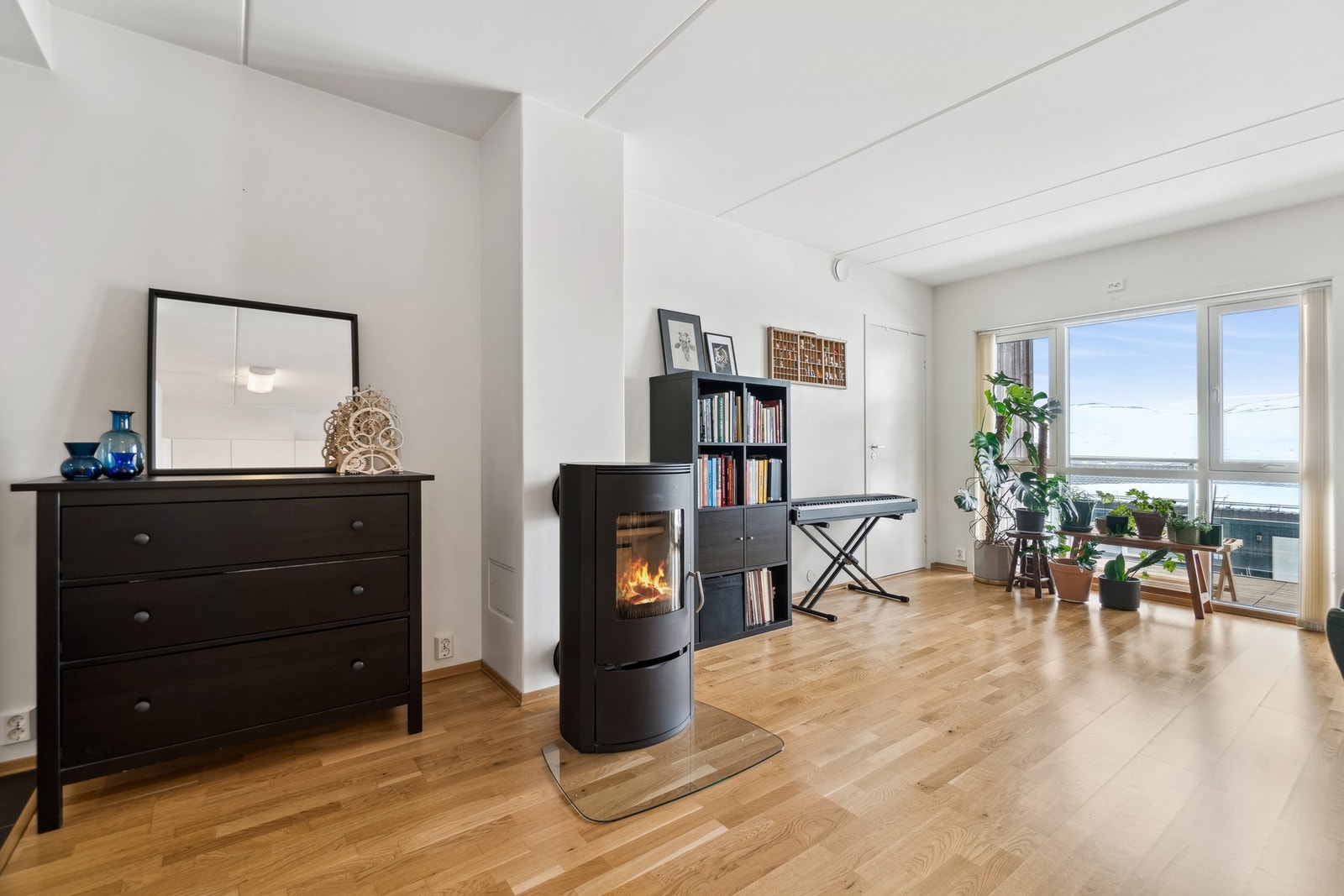 Boligen har en åpen stue-/kjøkkenløsning, og en vedovn sentrert i rommet for hygge og varme på kaldere årstider. Galleribilde