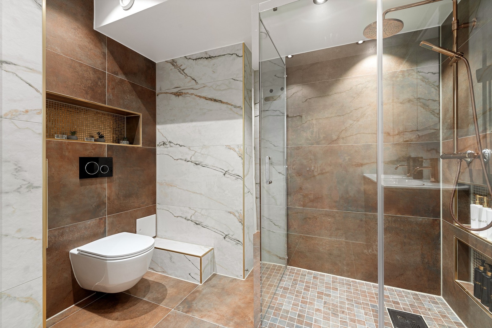 Badet har en romslig utforming med stor dusjsone, vegghengt toalett og dobbelservant. Galleribilde