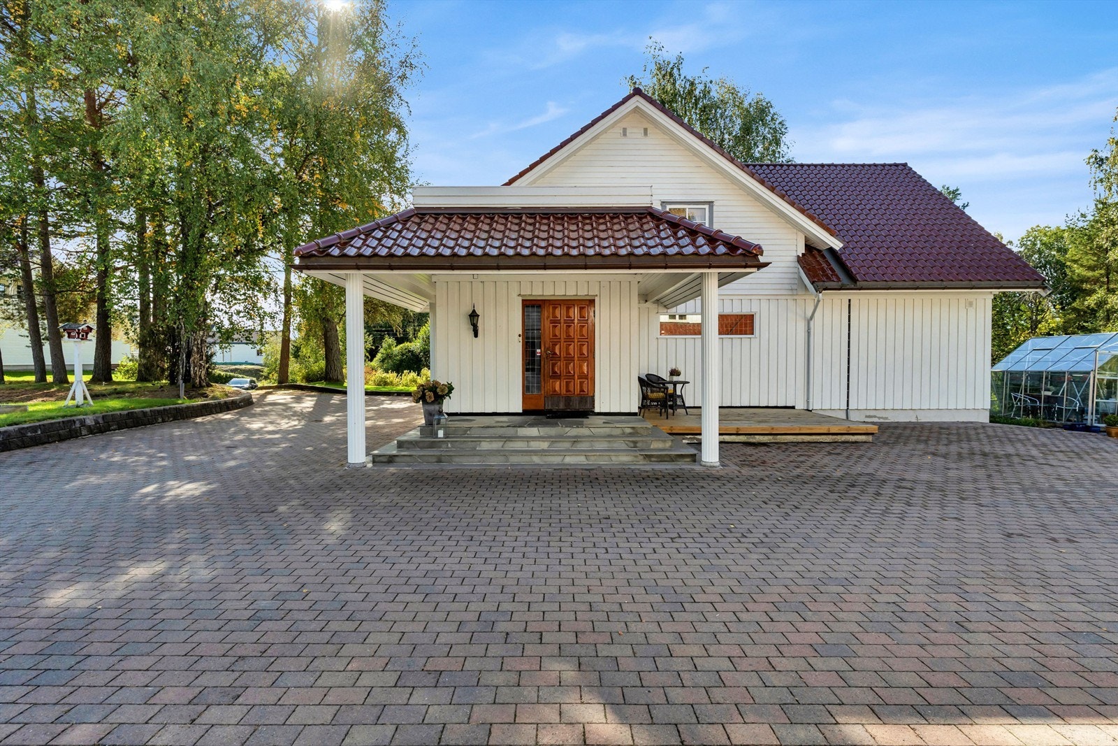 Boligen har et hyggelig inngangsparti med søyler og trapp belagt med skifer Galleribilde