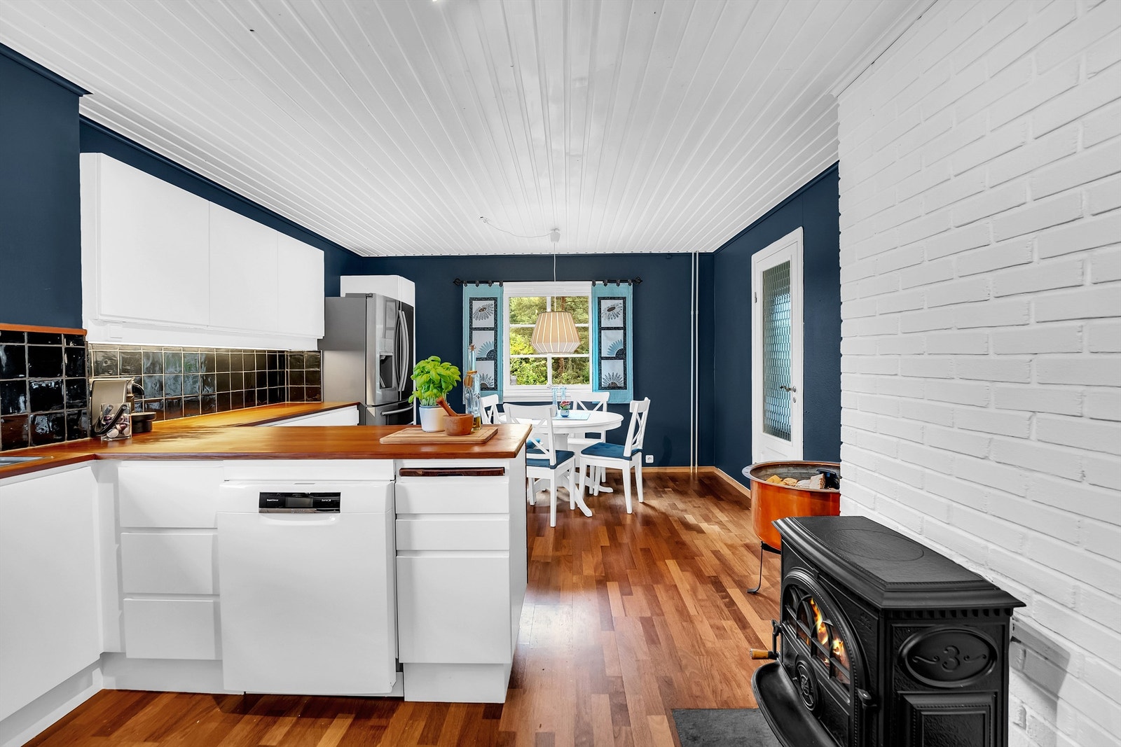 Rommet har en moderne blåfarge, og det er peisovn i rommet Galleribilde