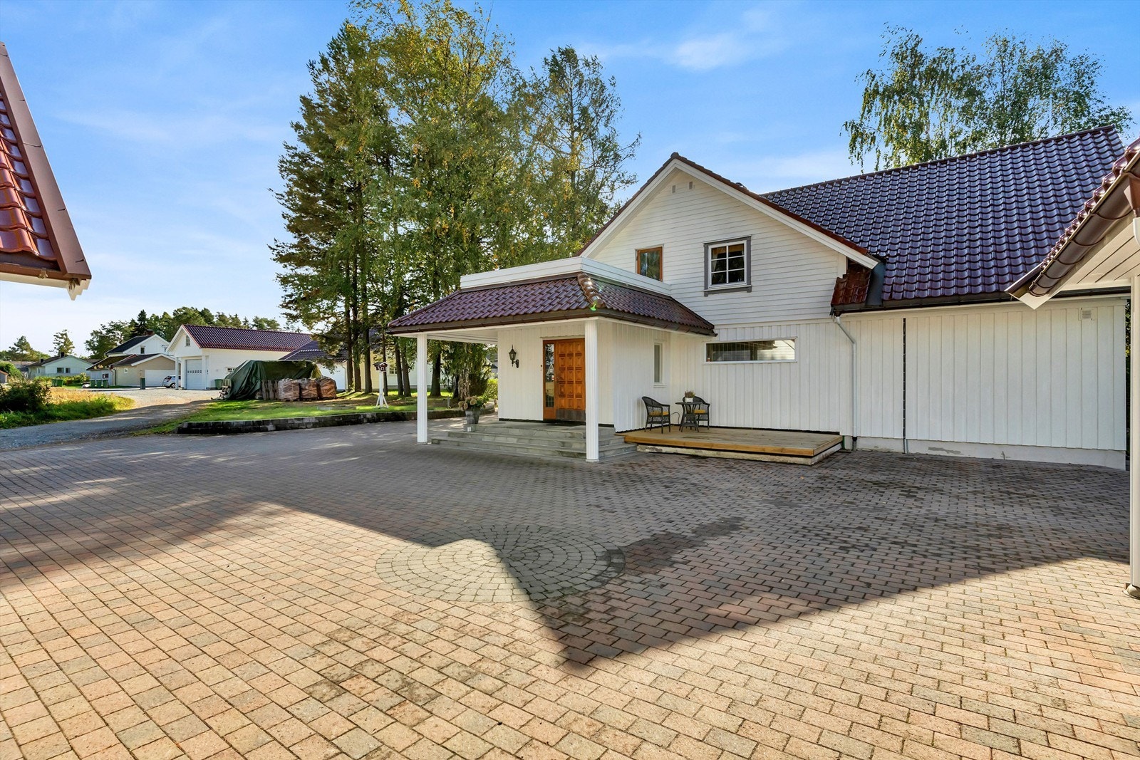 Steinbelagt gårdsplass mellom garasjen og boligen Galleribilde