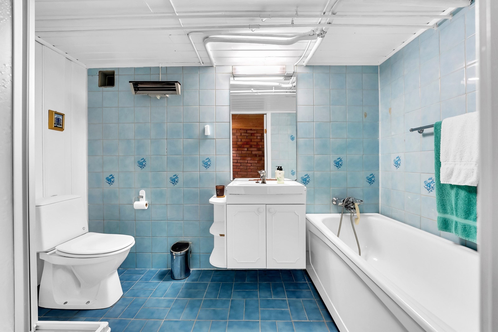 Kjelleretasjen har bad fra 1990 med flislagt gulv, flislagte og panel kledde veggflater. Badet har oppgraderingsbehov Galleribilde