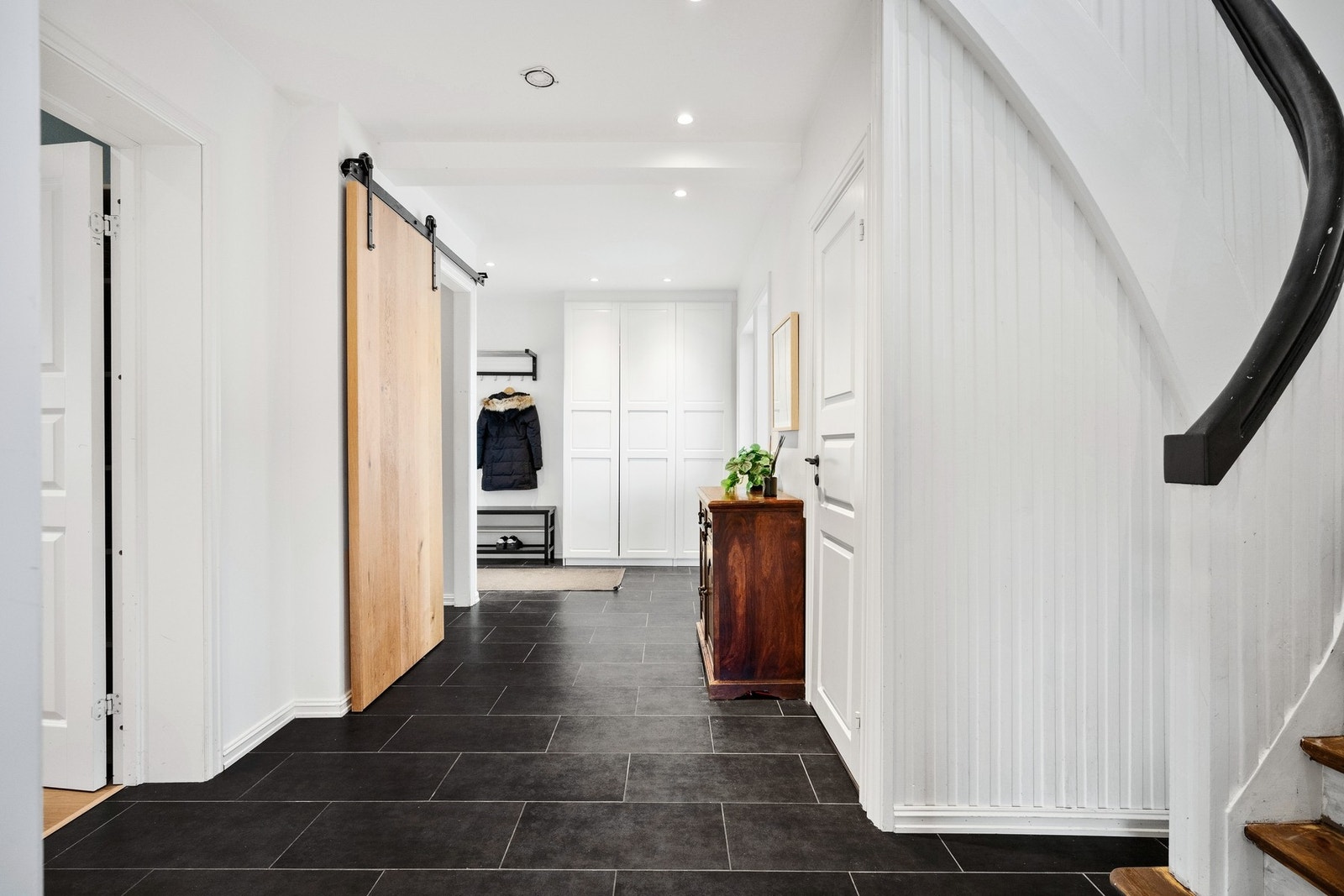 Man ønskes velkommen av en innbydende entré med varmekabler og store, sorte fliser på gulvet. Galleribilde