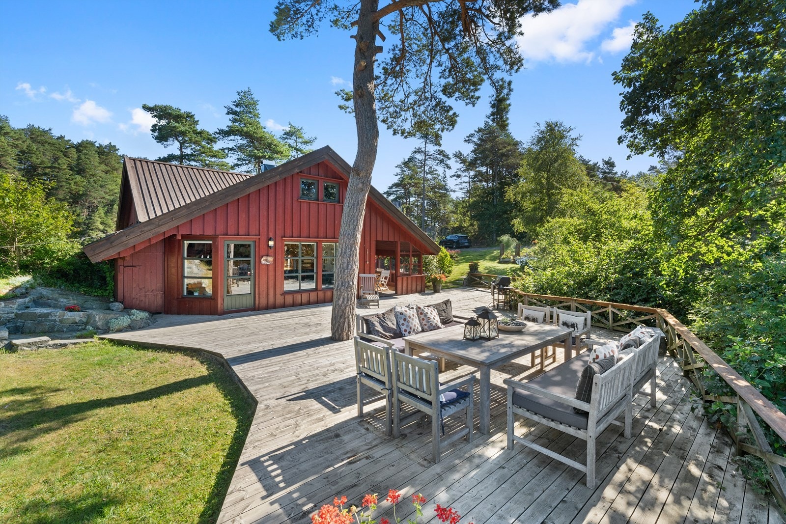 Hipp hipp hurra - terrassen foran hovedhytten hvor det er sol store deler av dagen og fin utsikt over tomten og sjøen Galleribilde