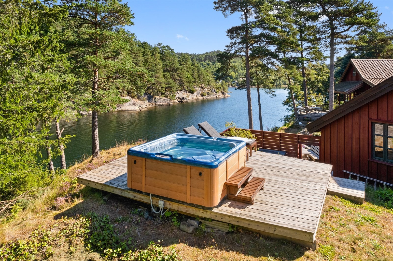 Ovenfor hytten er det etablert en plating med jacuzzi - herfra ser man sjøen på begge sider av eiendommen Galleribilde