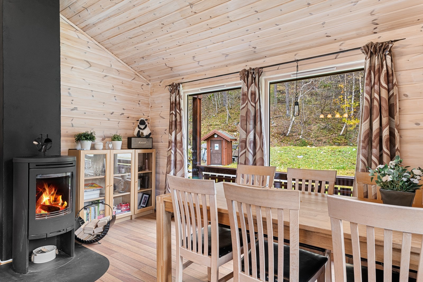 Hyttens stue fremstår som lys og trivelig med gode vindusflater som slipper inn mye naturlig lys som sammen med den ekstra takhøyden og vedovnen er med på å skape en svært god romfølelse og atmosfære. Galleribilde