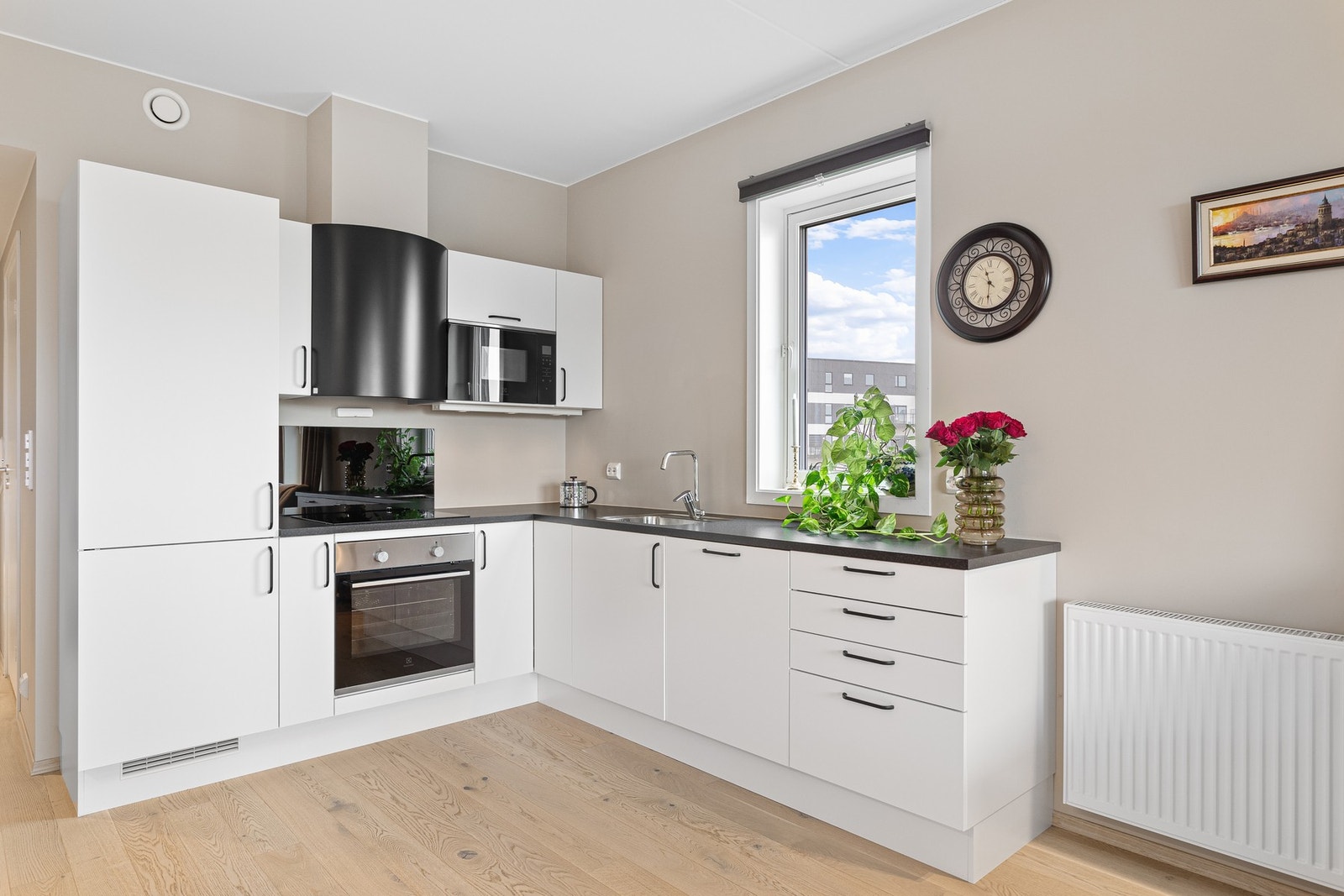 Stilrent kjøkken med integrerte hvitevarer og rikelig med skap- og benkeplass. Galleribilde