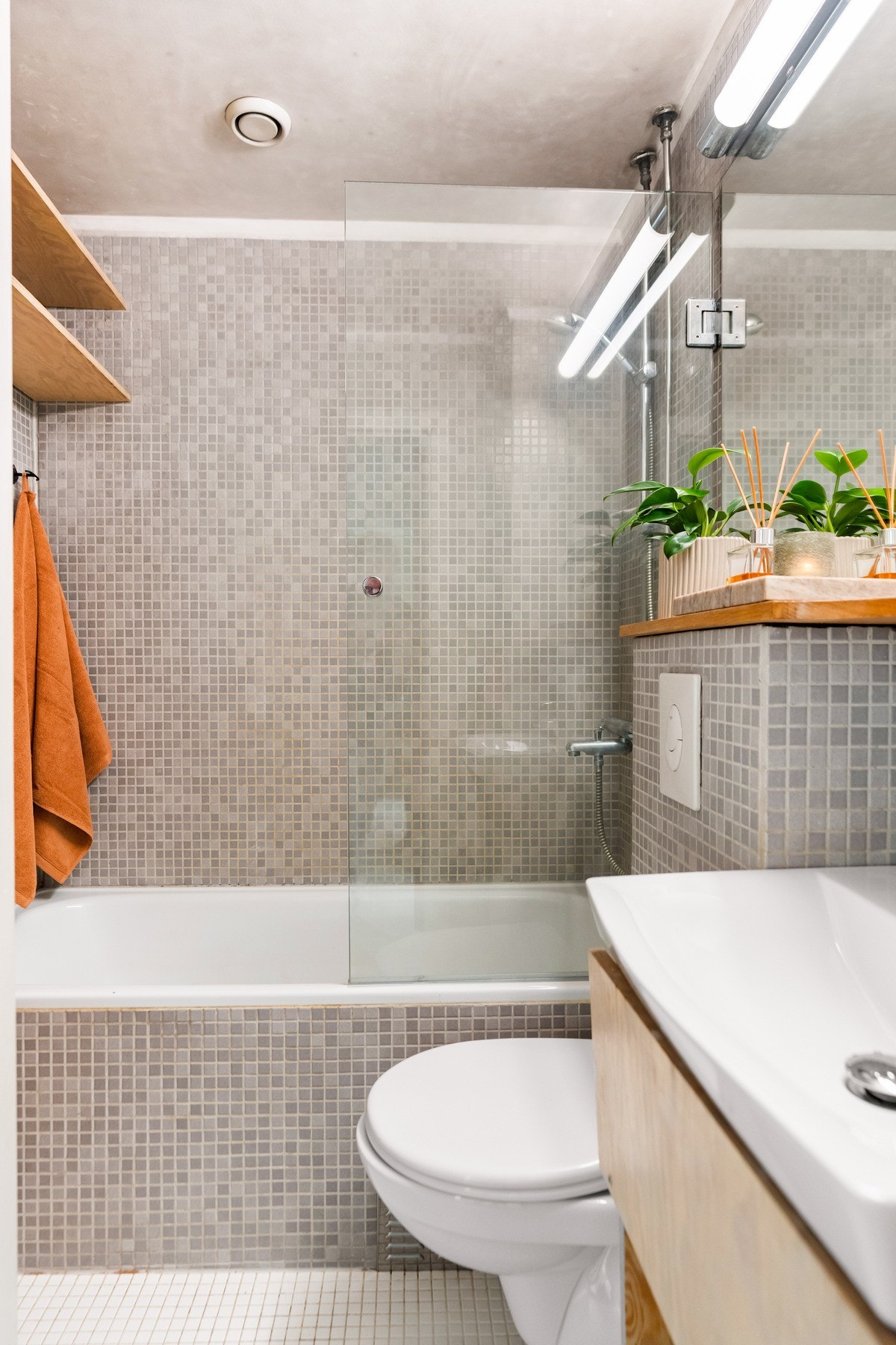 Badet har flislagte gulv og vegger i nøytrale farger. Galleribilde