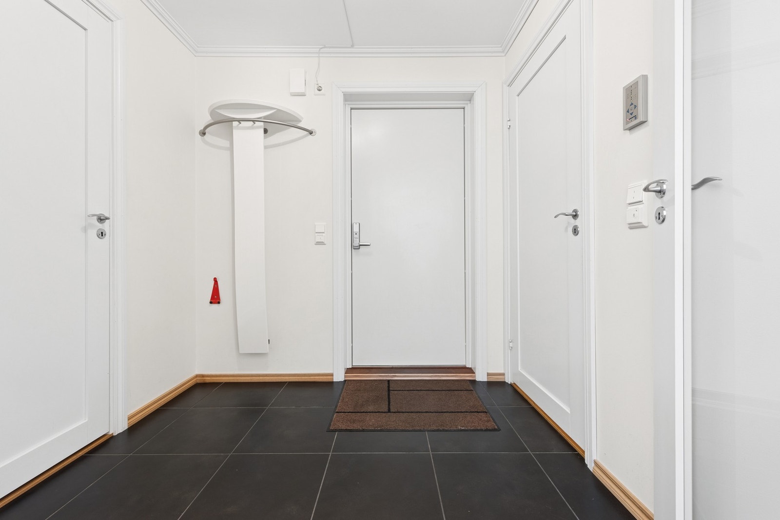 Entréen har flislagt gulv med plass til oppheng og oppbevaring - et praktisk og ryddig førsteinntrykk. Galleribilde