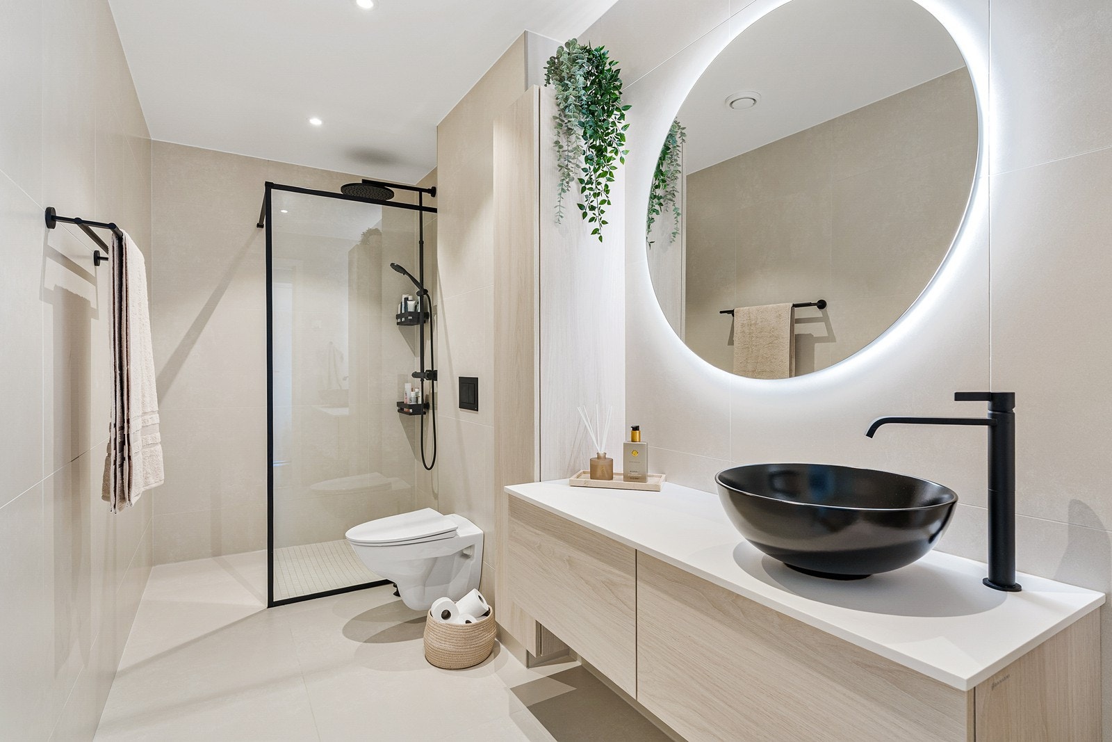 Badet er helfliset med lyse gulv- og veggfliser, mens himlingen er slett gips med downlights. Galleribilde