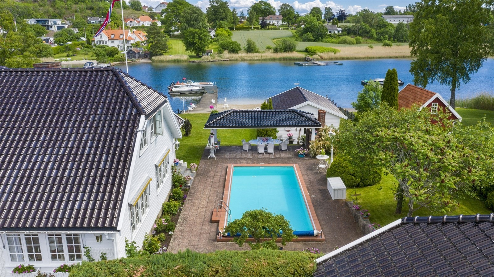 Langs sydsiden av boligen er det en hellelagt uteplass med basseng, en glede på varme sommerdager. Galleribilde