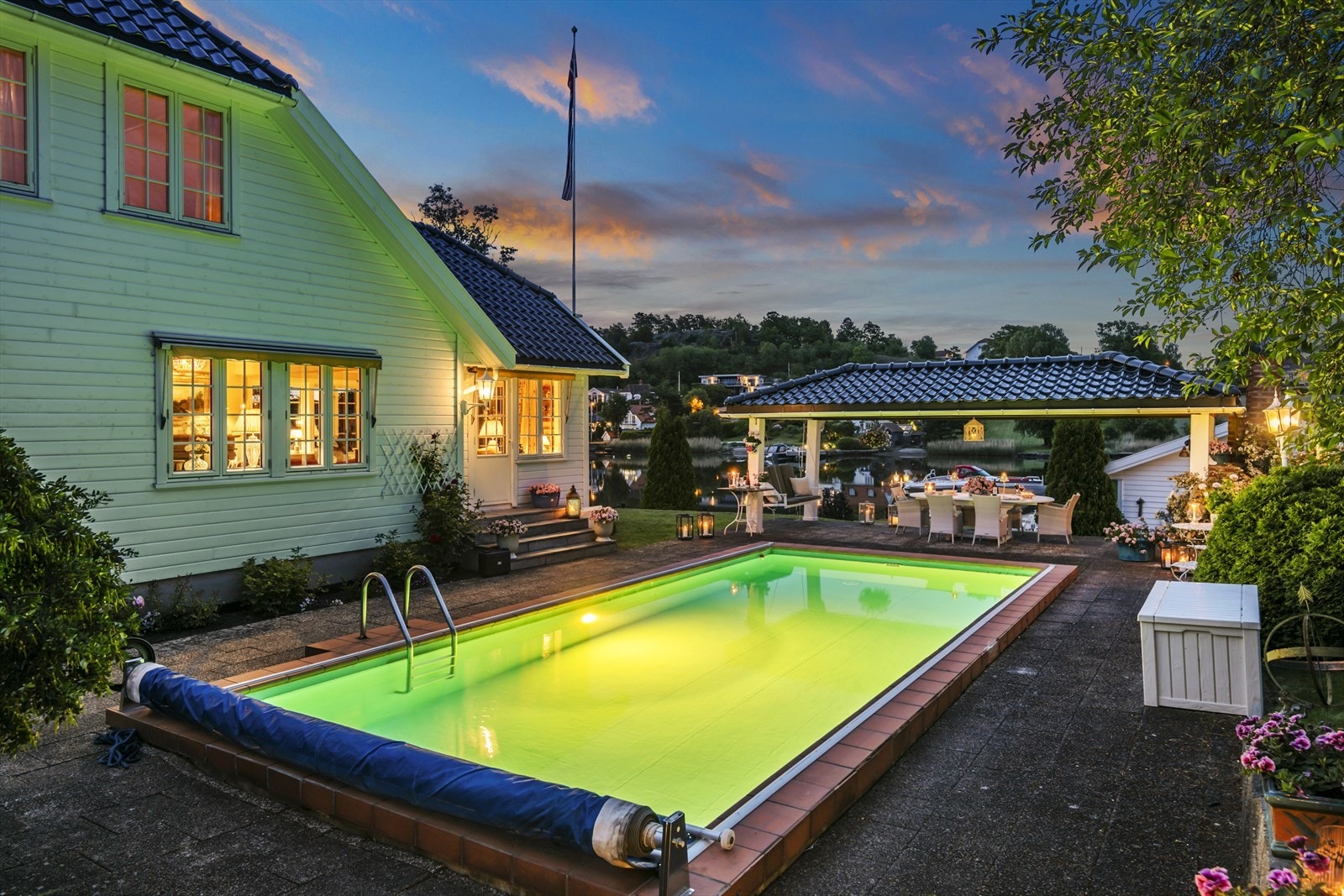 Fra peisestuen i første etasje er det utgang til hellelagt uteareal med svømmebasseng og skjermet spiseplass. Galleribilde