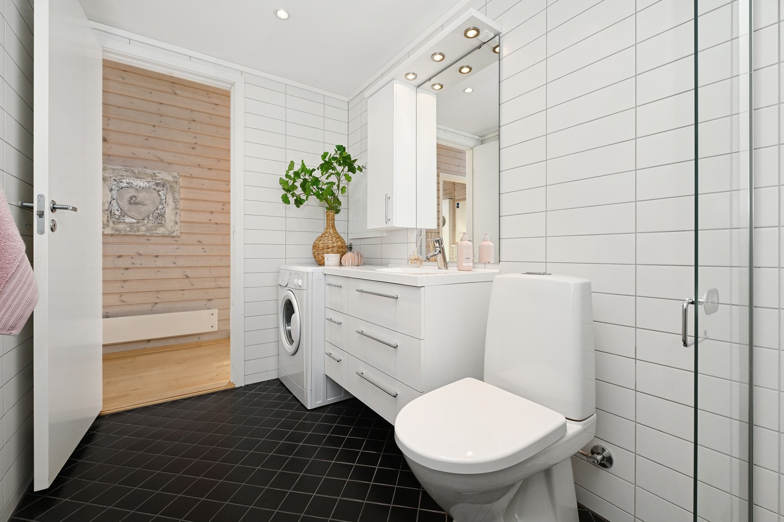 Badet er innredet med nedfelt servant, gulvfestet toalett, dusjhjørne og opplegg for vaskemaskin.Vaskemaskin medfølger. Galleribilde