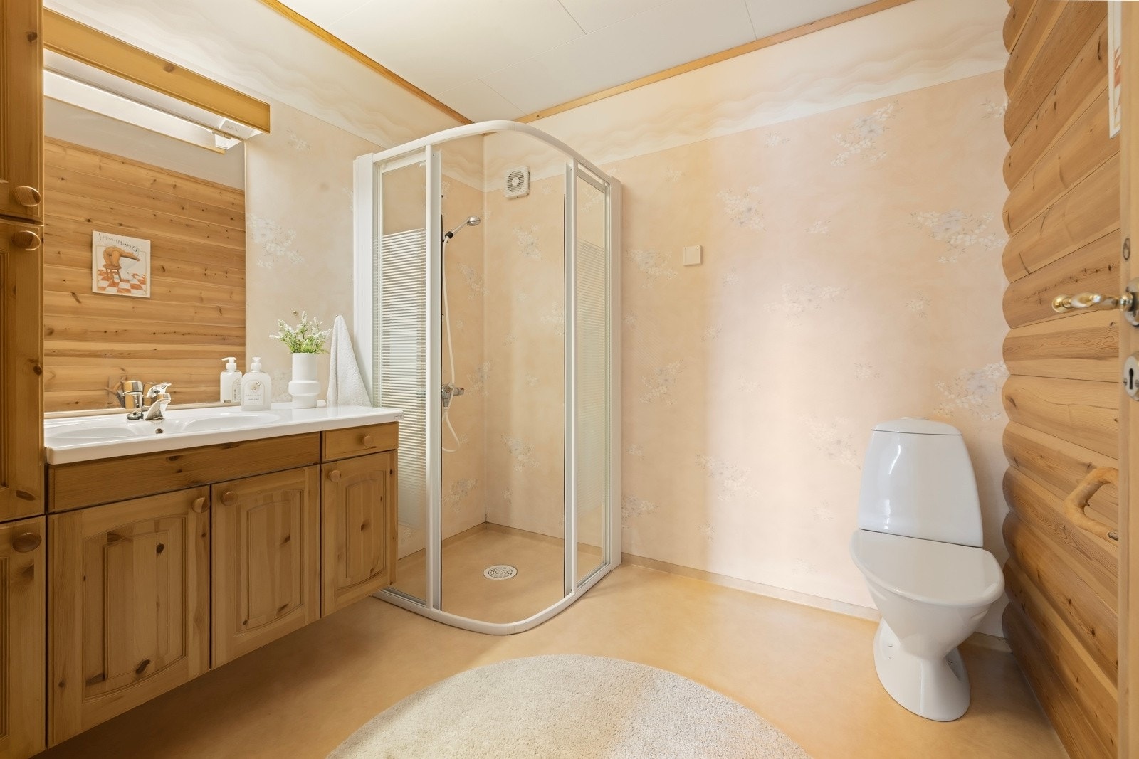 Badet i kjeller består av vinylbelegg på gulv og våtromstapet/belegg og trepanel på vegg. Innredet med toalett, servant og dusjvegger Galleribilde