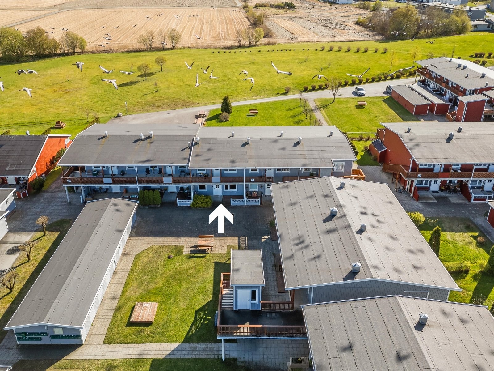 Leiligheten ligger på rekka helt ytterst i feltet. Utsikt over fellesarealer og dyrkamark. Galleribilde