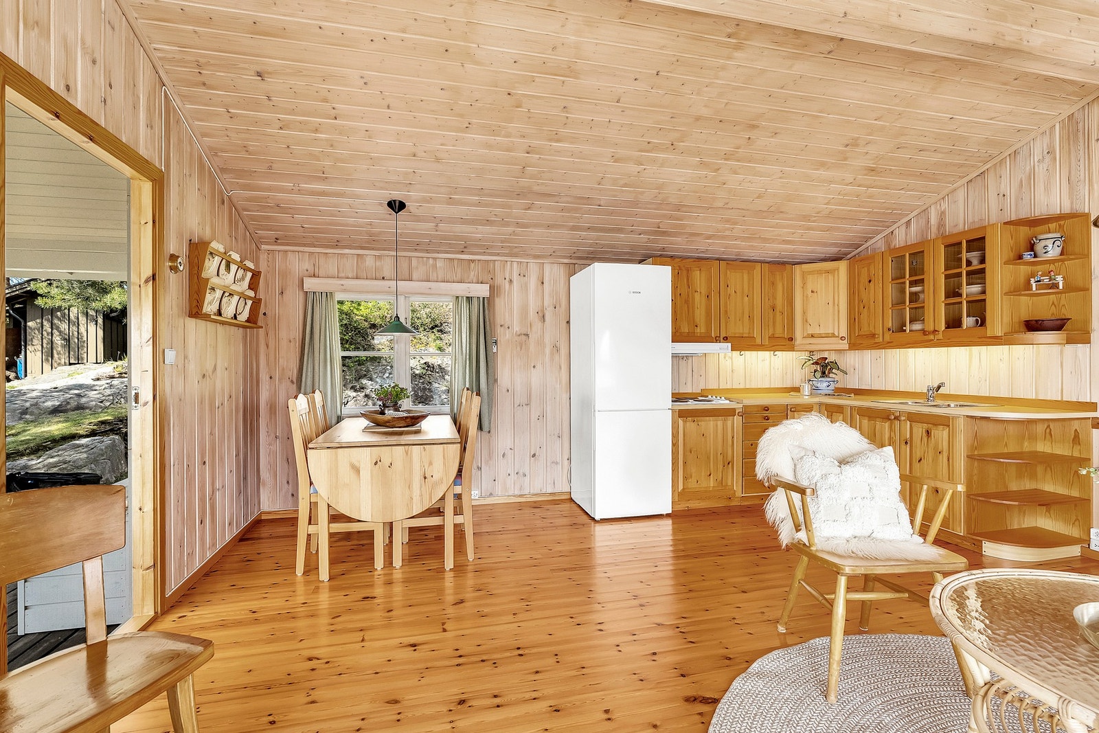 Kjøkkenet er praktisk innredet med folierte skrog og fronter i tre, samt en foliert benkeplate med integrert vask. Galleribilde