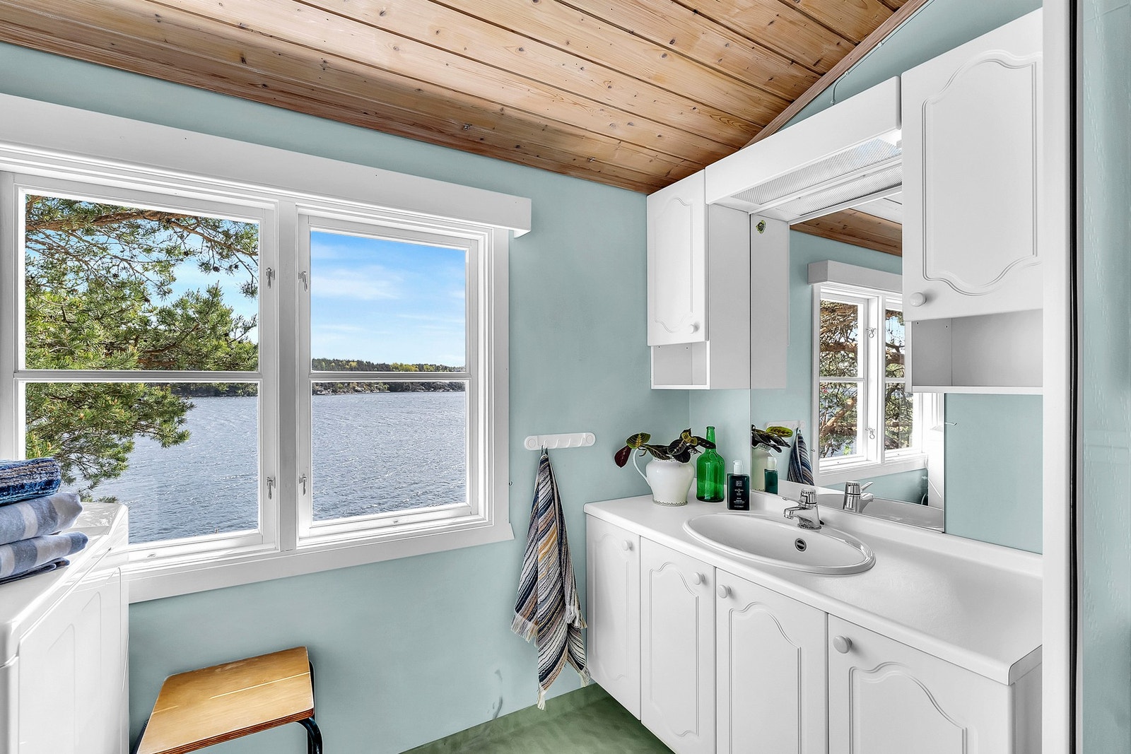 Badet er utstyrt med dusjkabinett, servant med innredning og opplegg for vaskemaskin. Galleribilde