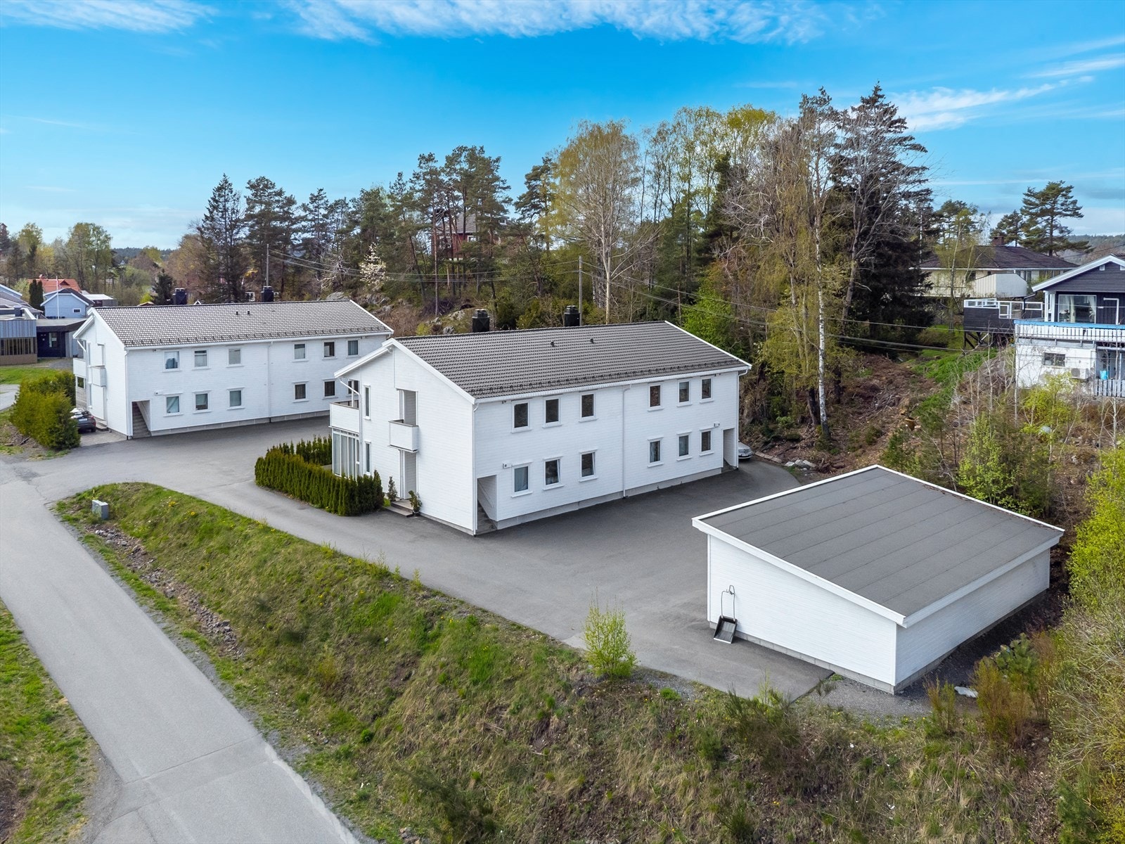Felles tomt som er opparbeidet med asfalterte parkeringsarealer og carport i rekke. Galleribilde
