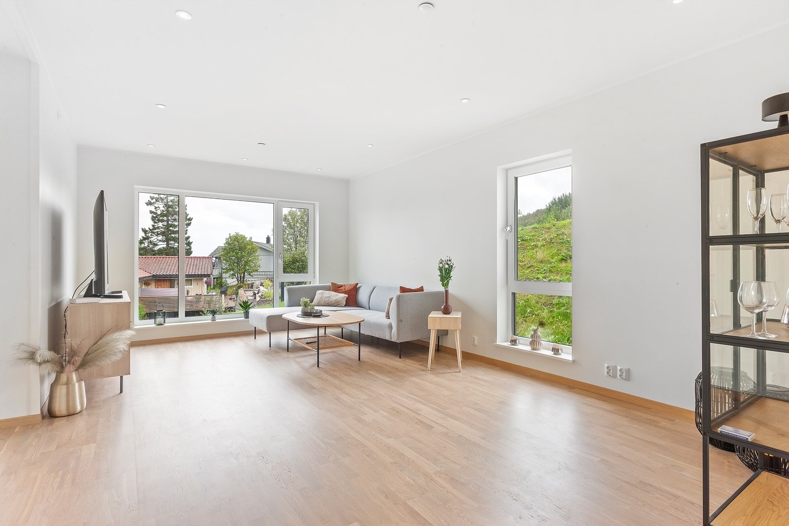 Stuen har "L-form" og godt med veggplass for innredning. Her kan du boltre deg på mange kvadratmeter parkett. Galleribilde