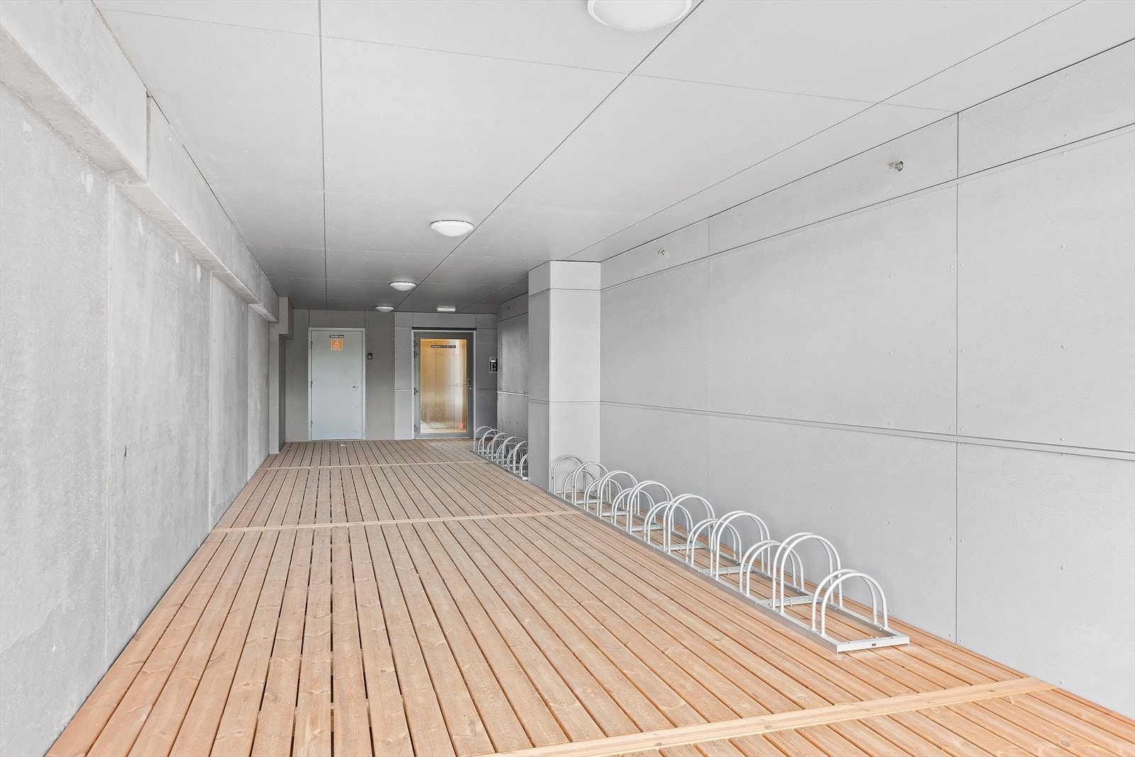 Takoverbygd sykkelparkering ved inngangen rett under leiligheten Galleribilde