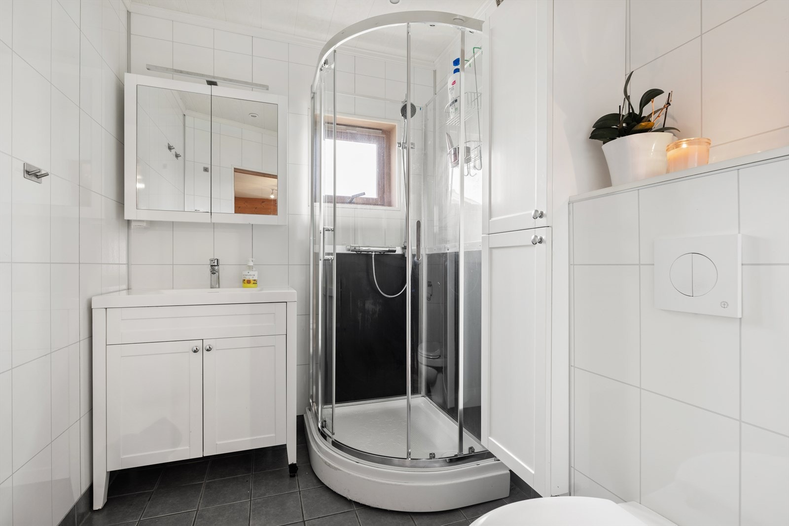 Boligen inneholder to bad, ett på hvert plan, samt et separat toalettrom i underetasjen. Badene har flislagte gulv og våtromspanel på veggene, og fremstår som eldre og med behov for oppgradering. Galleribilde