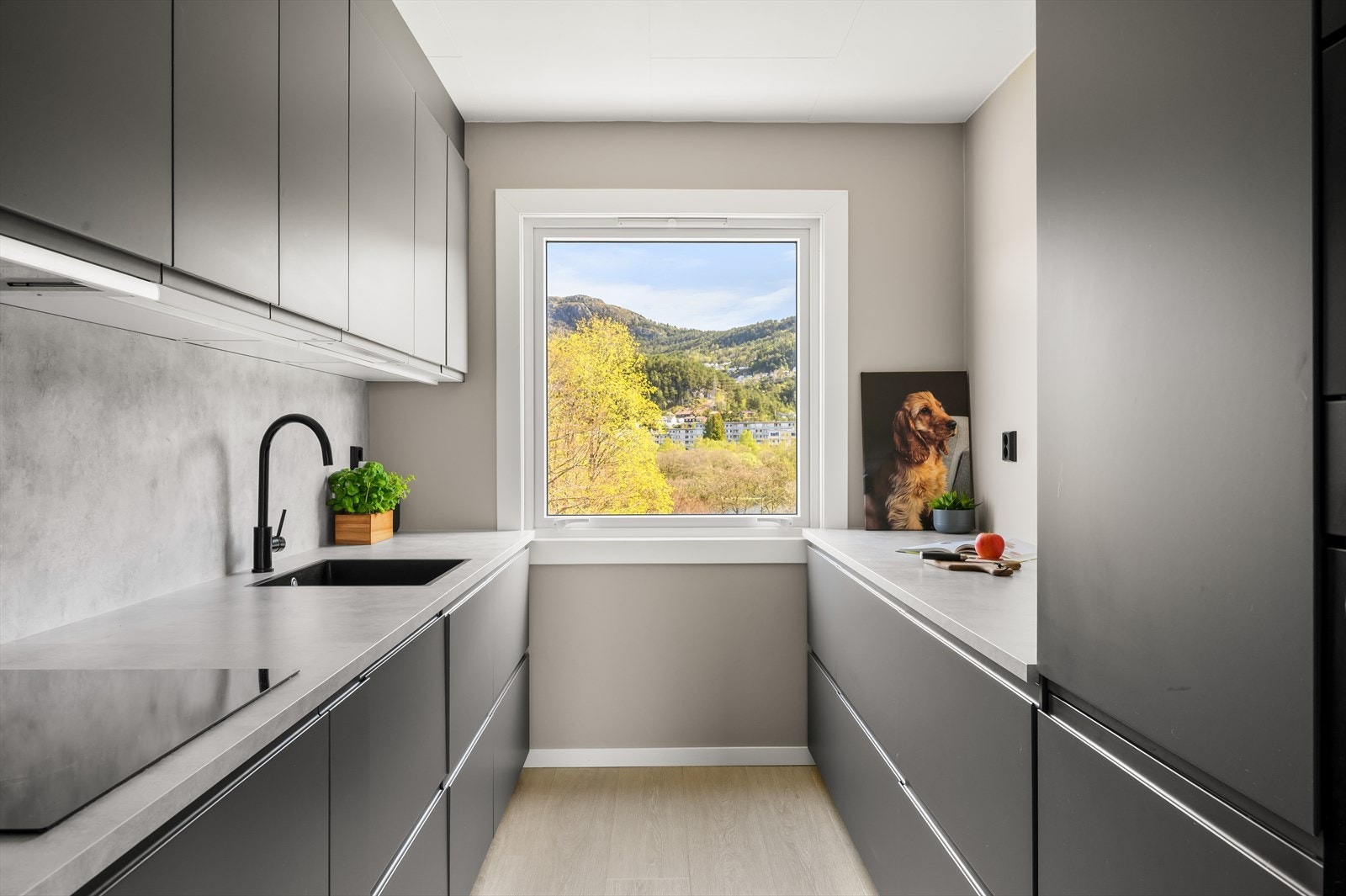 Innredningen er utført med slette fronter, laminat benkeplate, og skvettplate over benkeplate ved vask og platetopp. Galleribilde