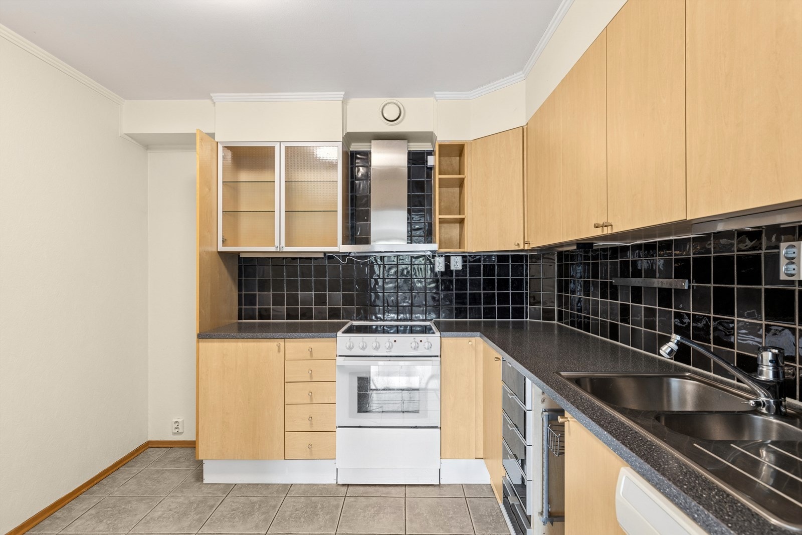 Kjøkkeninnredningen har laminat fronter, 2 overskap med glass og en skuffeseksjon med fronter av plast. Galleribilde