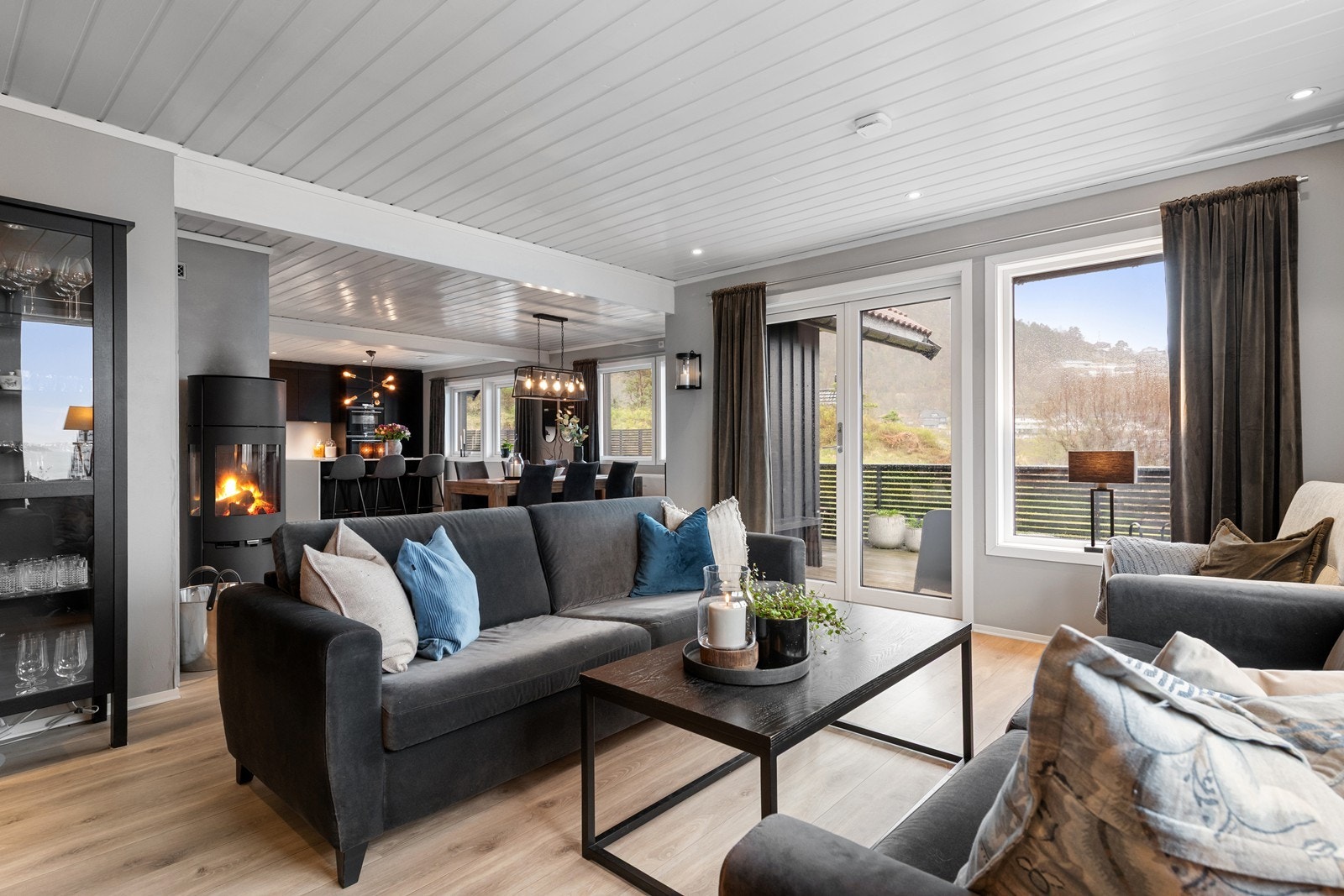 Stue med vedfyrt peis og utgang til terrasse Galleribilde