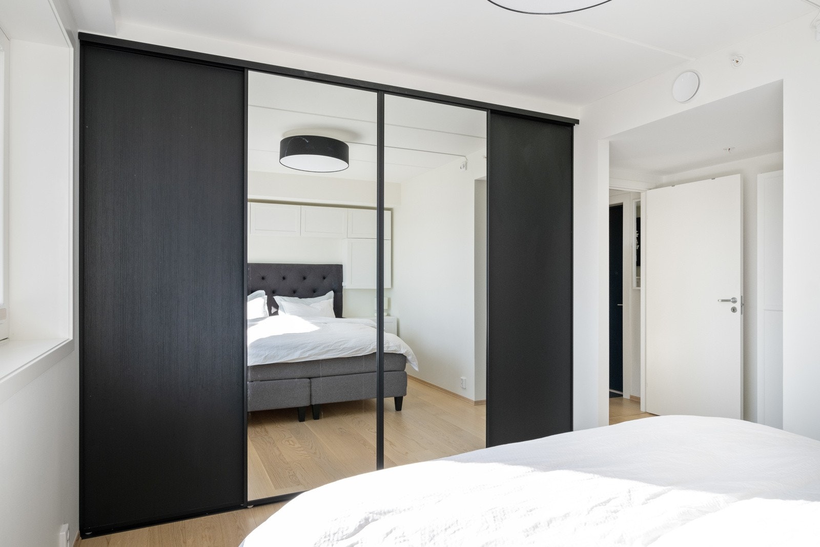 Det er skyvedørsgarderobe langs hele den ene veggen. Galleribilde