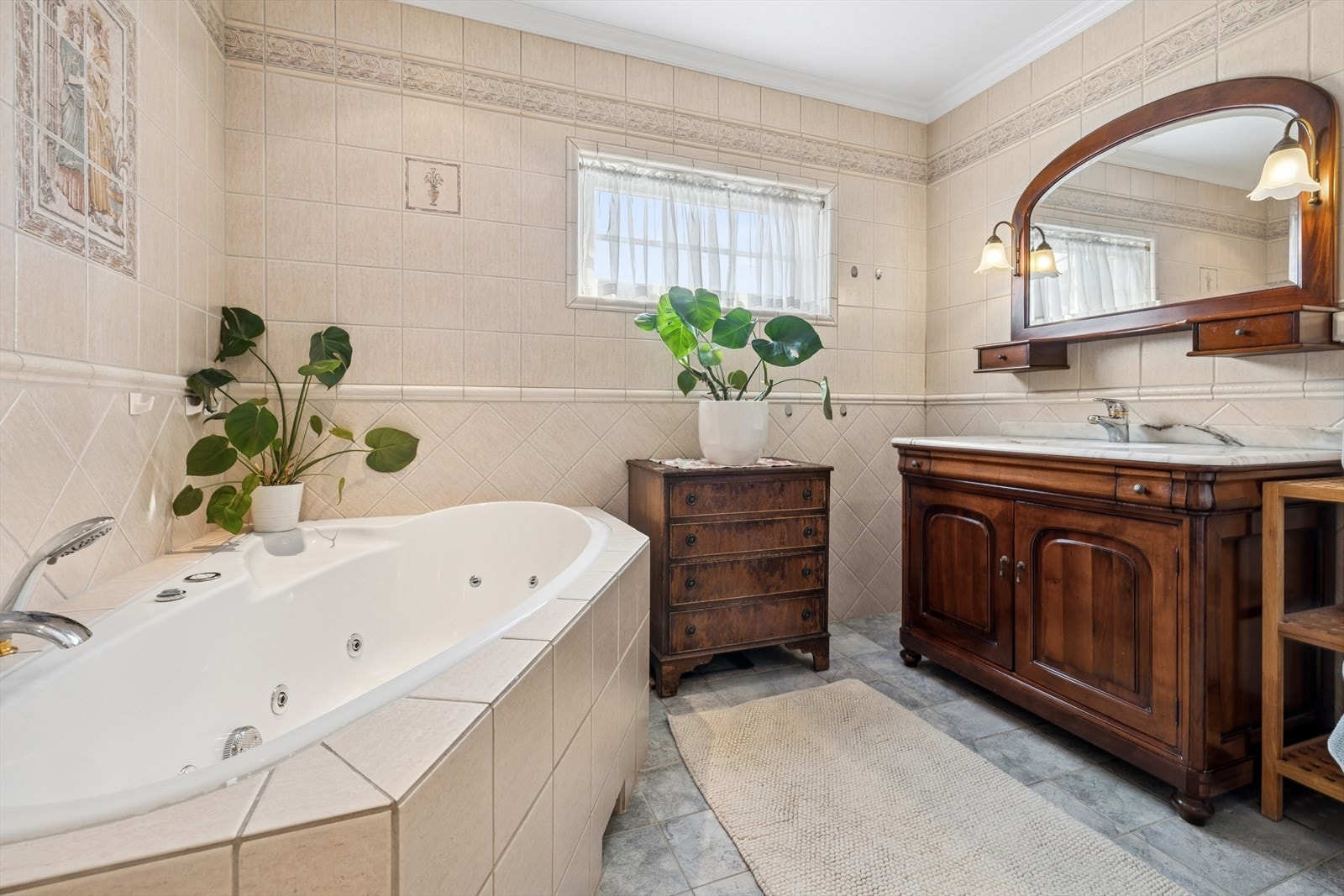 Videre er rommet utstyrt med baderomsinnredning med heldekkende servant, speil på vegg, gulvmontert toalett, innmurt badekar og dusjhjørne. Galleribilde