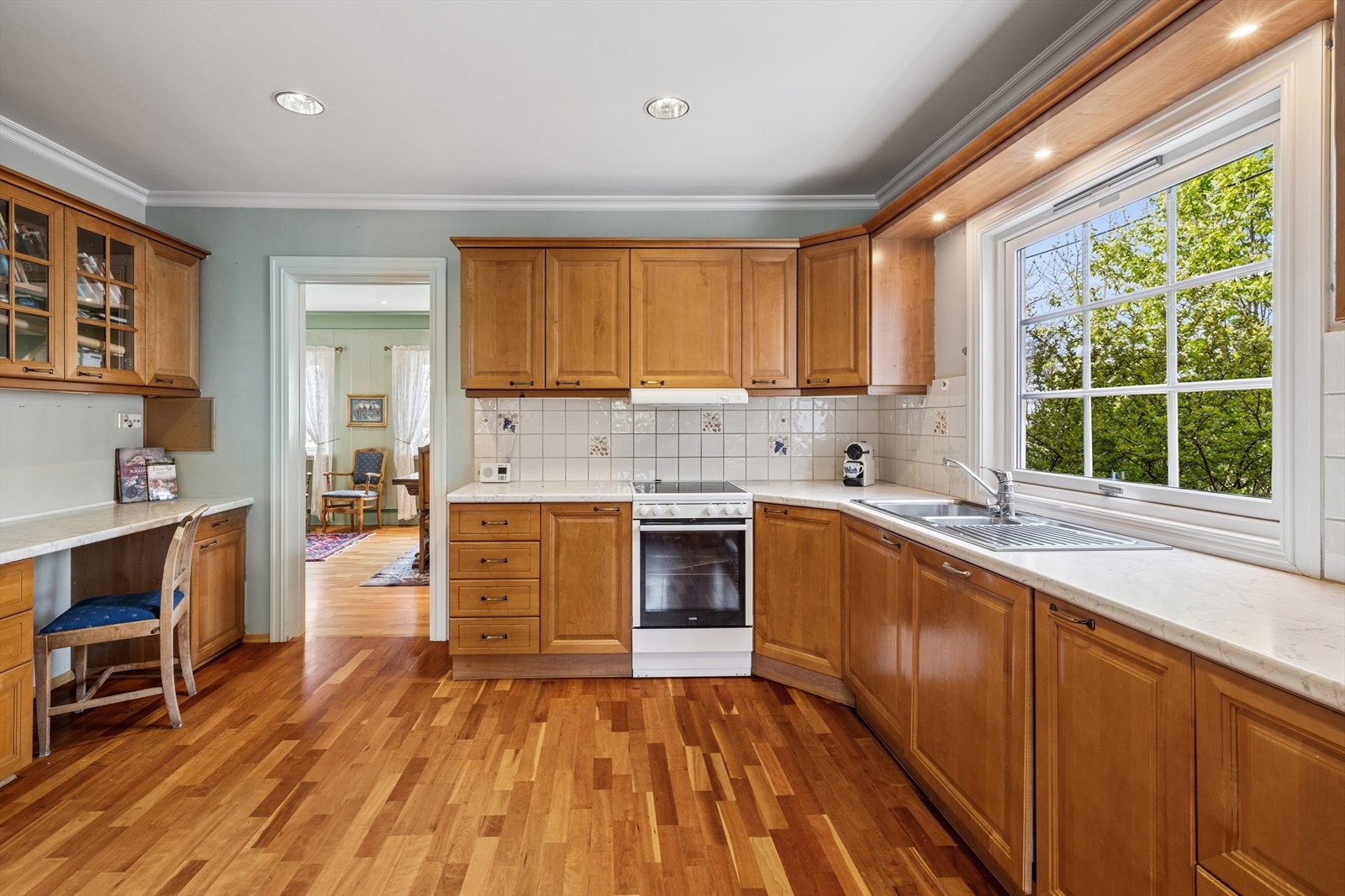 Det er adkomst til kjøkkenet fra stuen, som gjør rommet mer sosialt ved besøk. Kjøkkenet er innredet i en praktisk form, med godt med skap- og oppbevaringsplass. Galleribilde